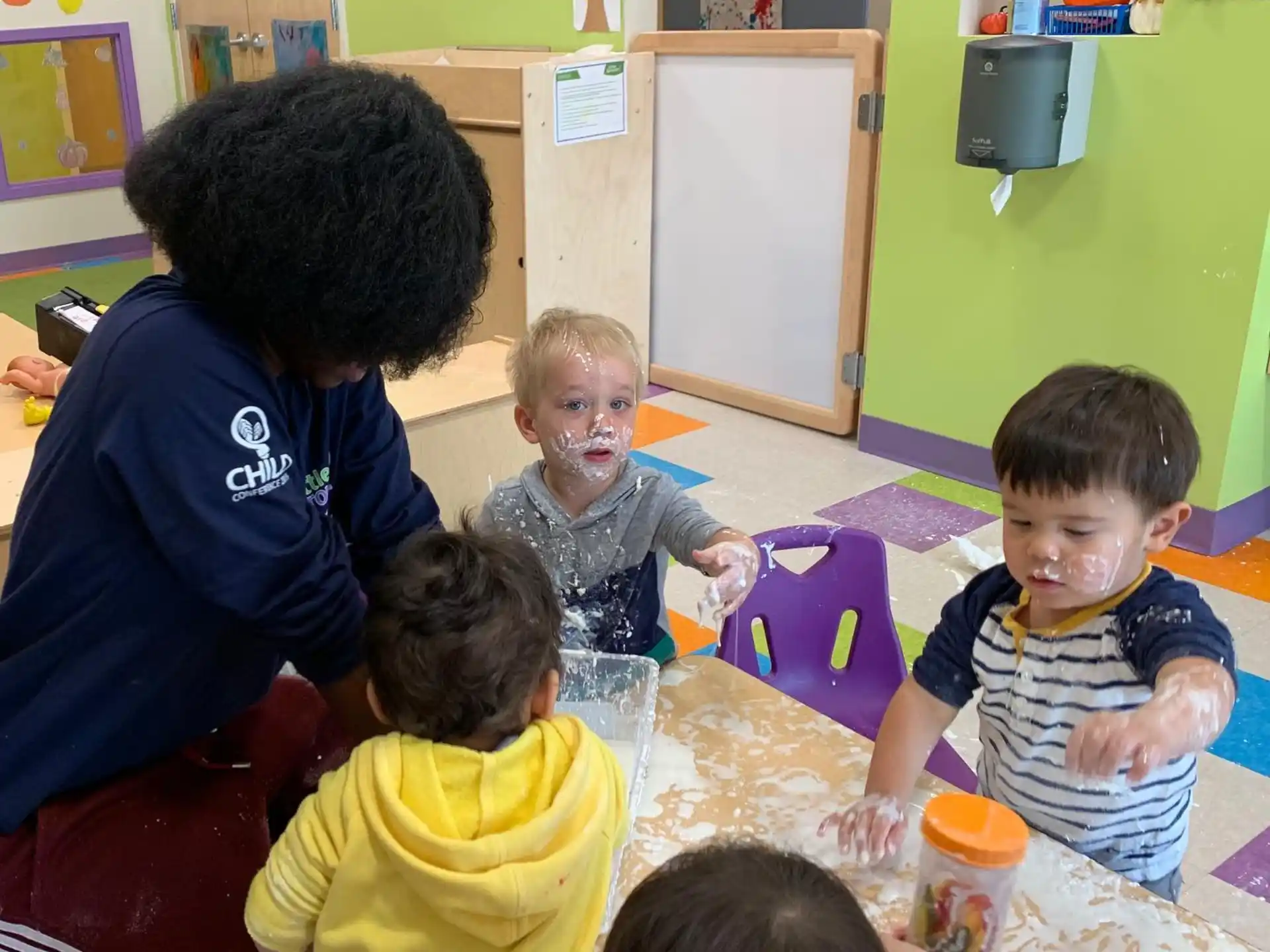 a person and several children sitting at a table