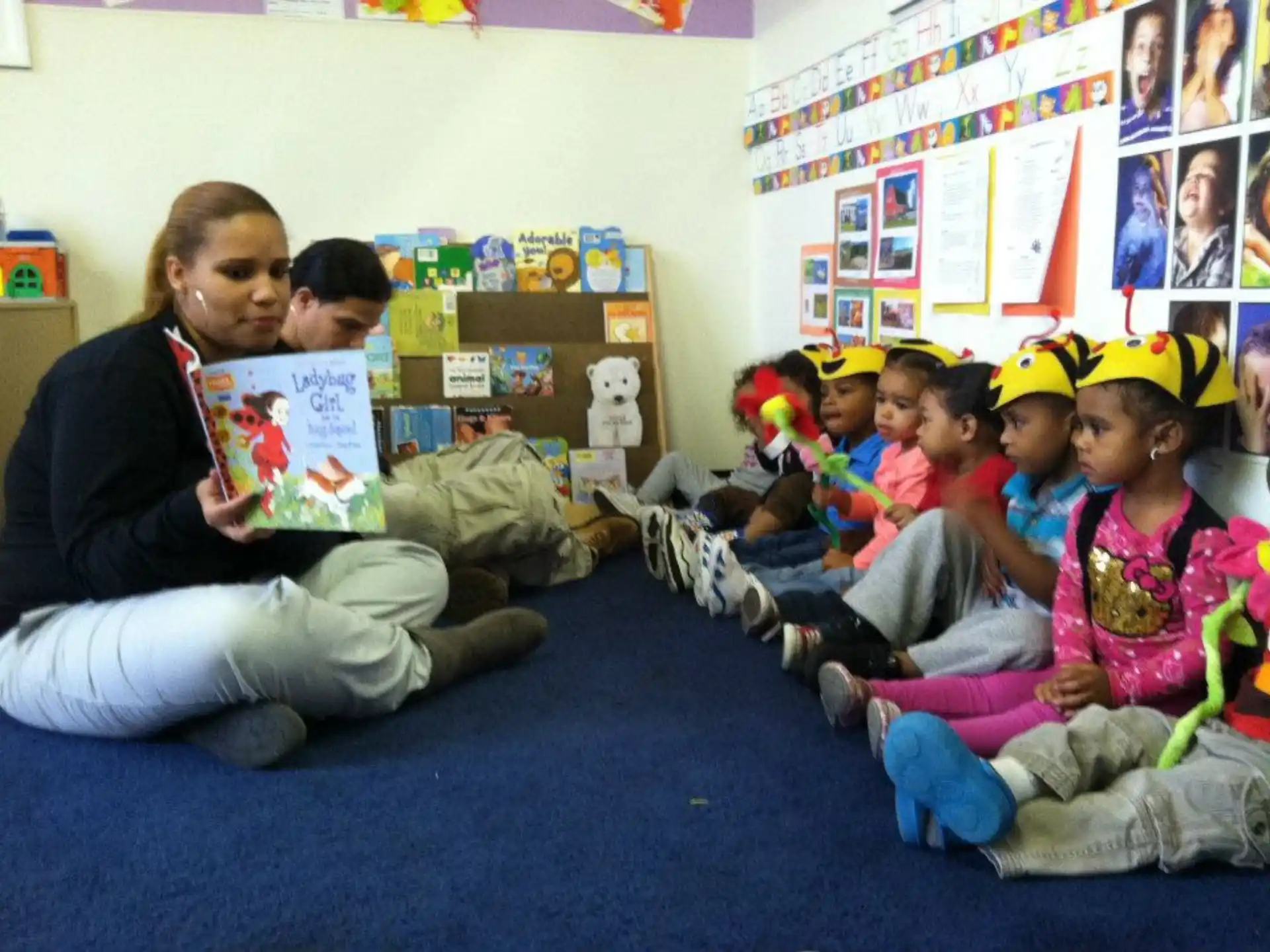 a person reading a book to a group of children