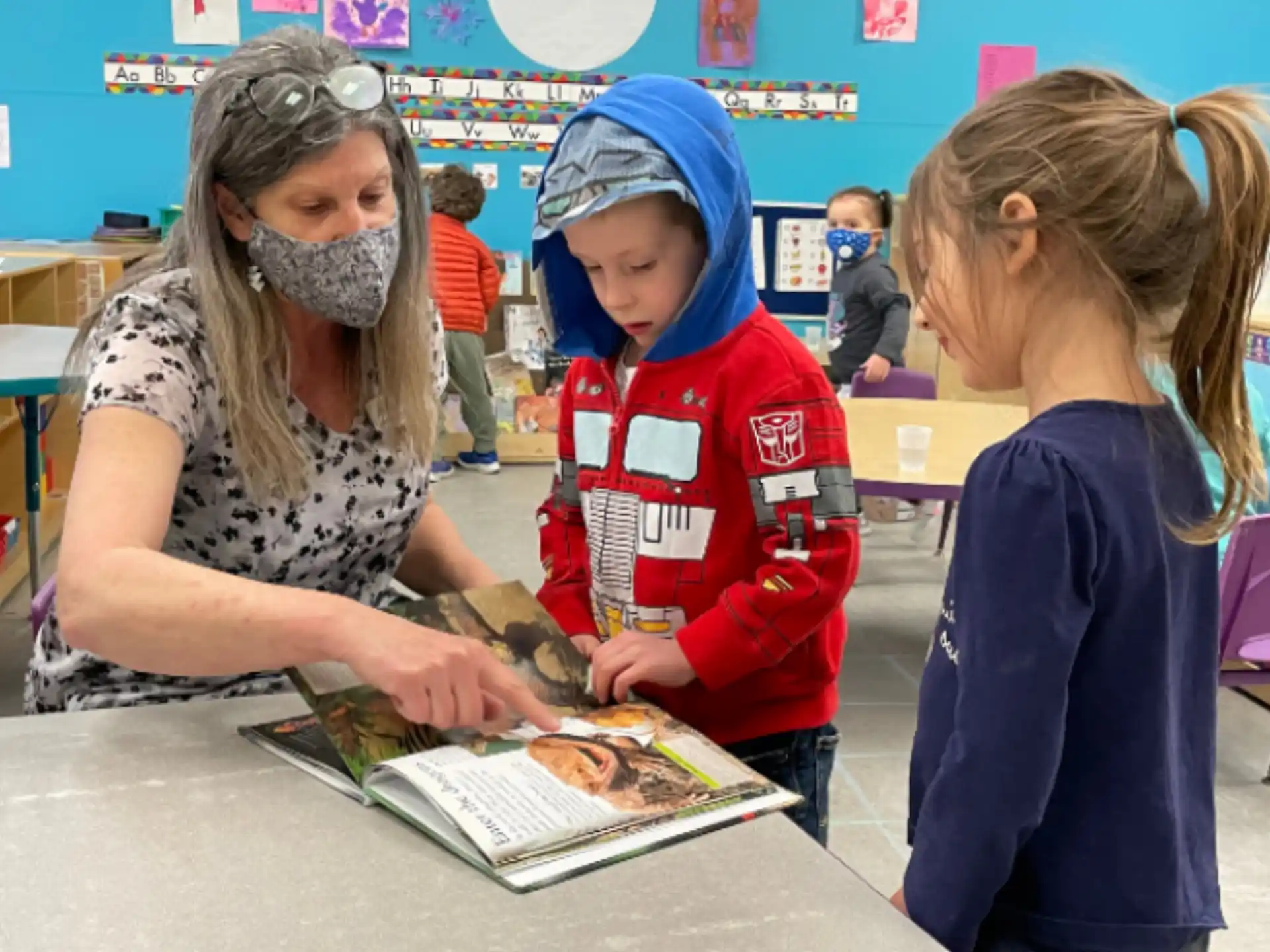 a group of children looking at a book