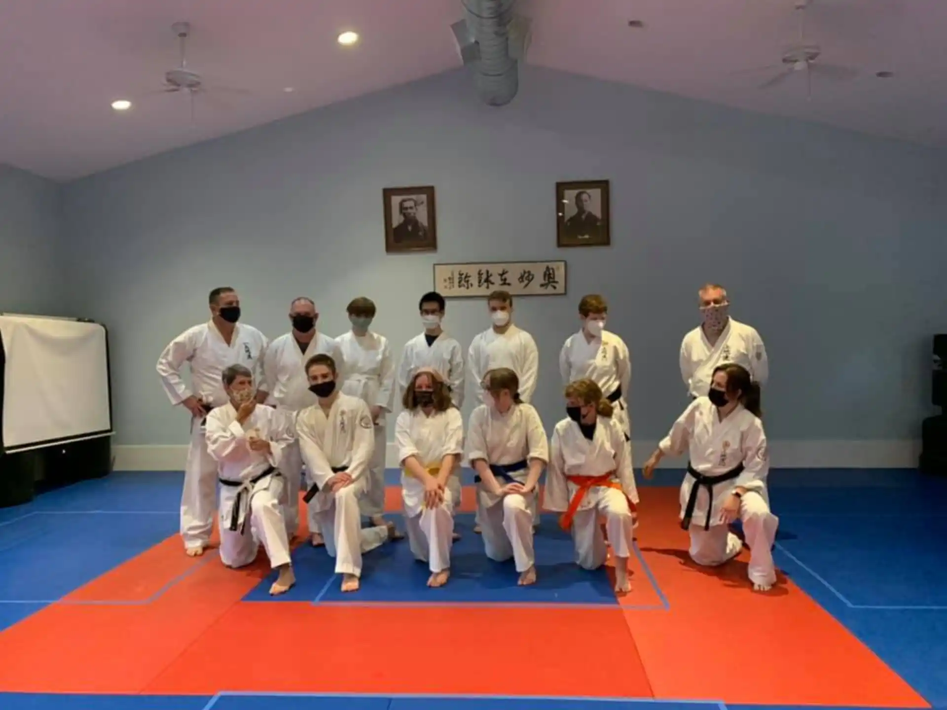 a group of people in white karate uniforms posing for a photo