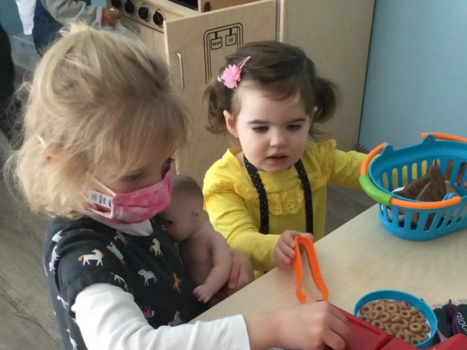 a couple of young girls playing with toys