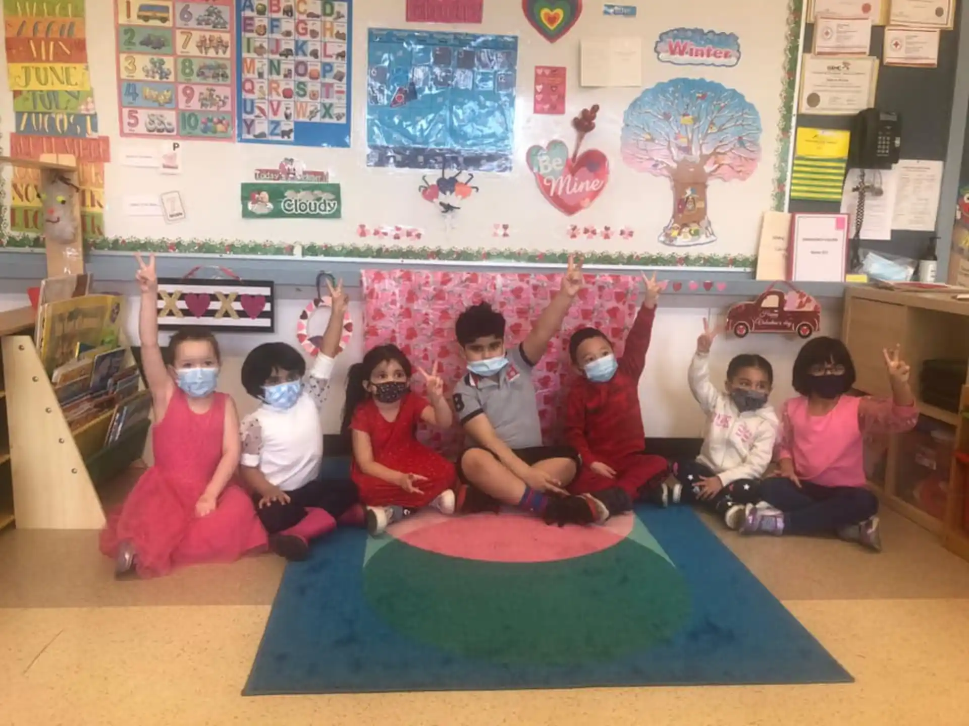 a group of children sitting on the floor in a classroom