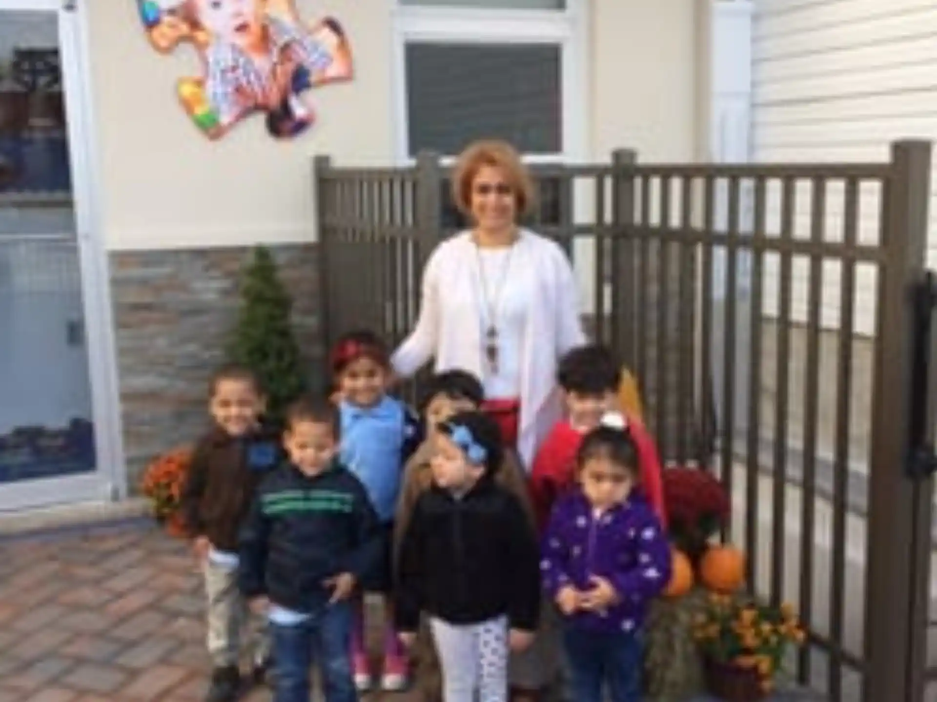 a group of children posing for a photo in front of a house
