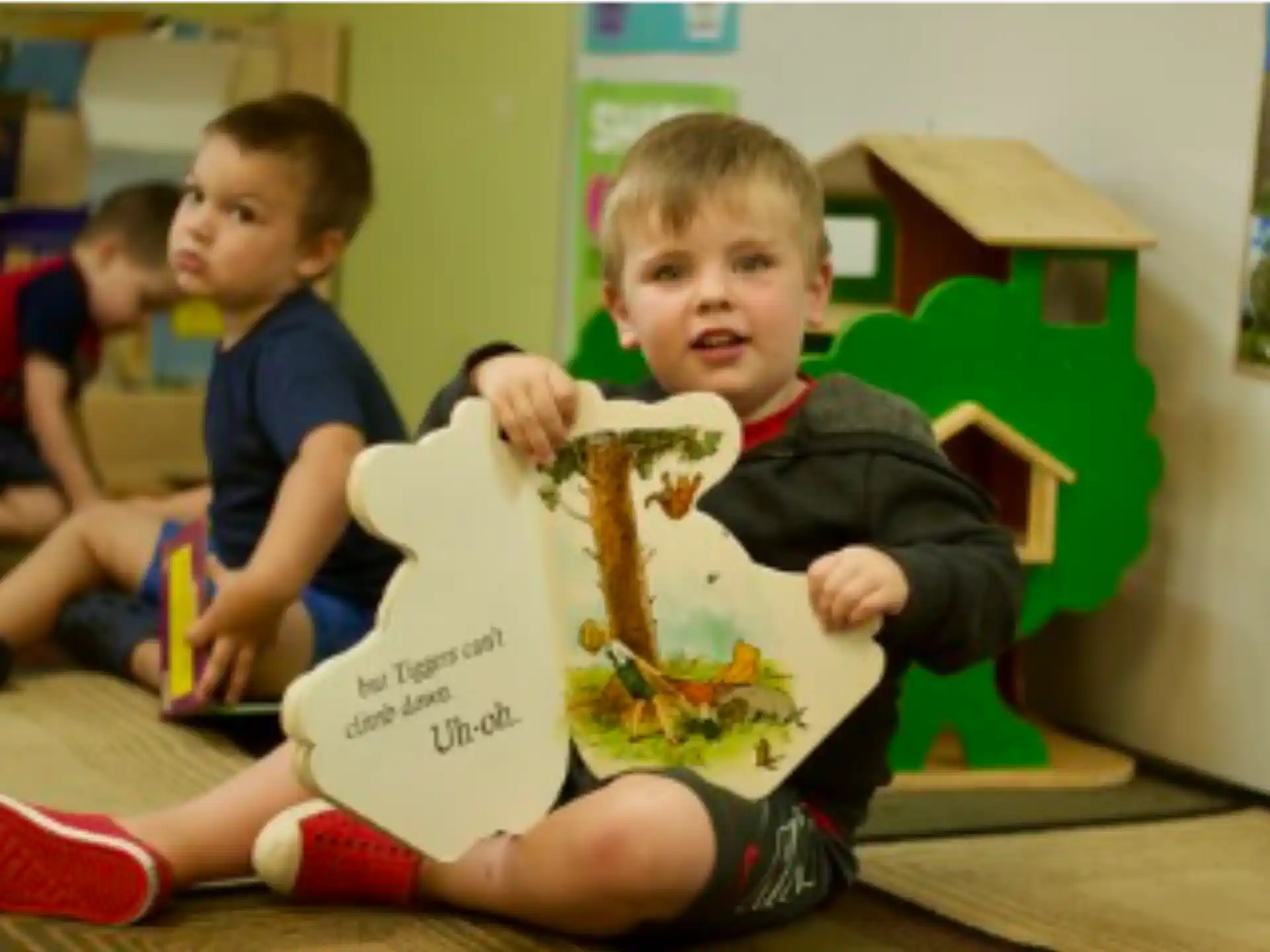 a group of boys sitting in a room with a cardboard box