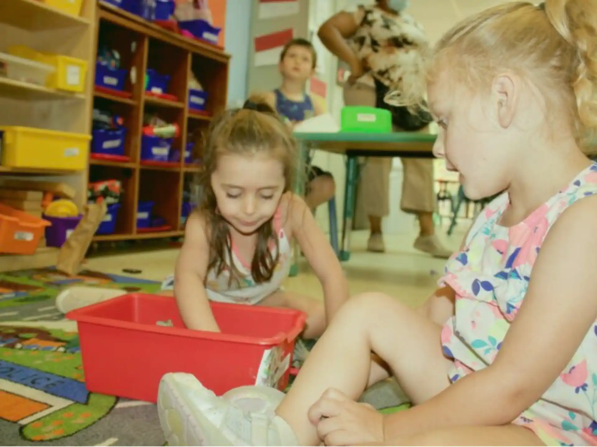 a person and a child playing with toys in a room