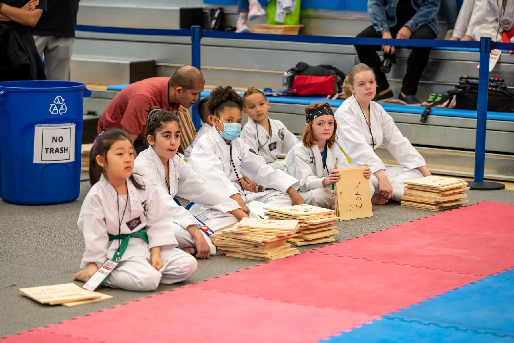 a group of people in white uniforms sitting on a mat