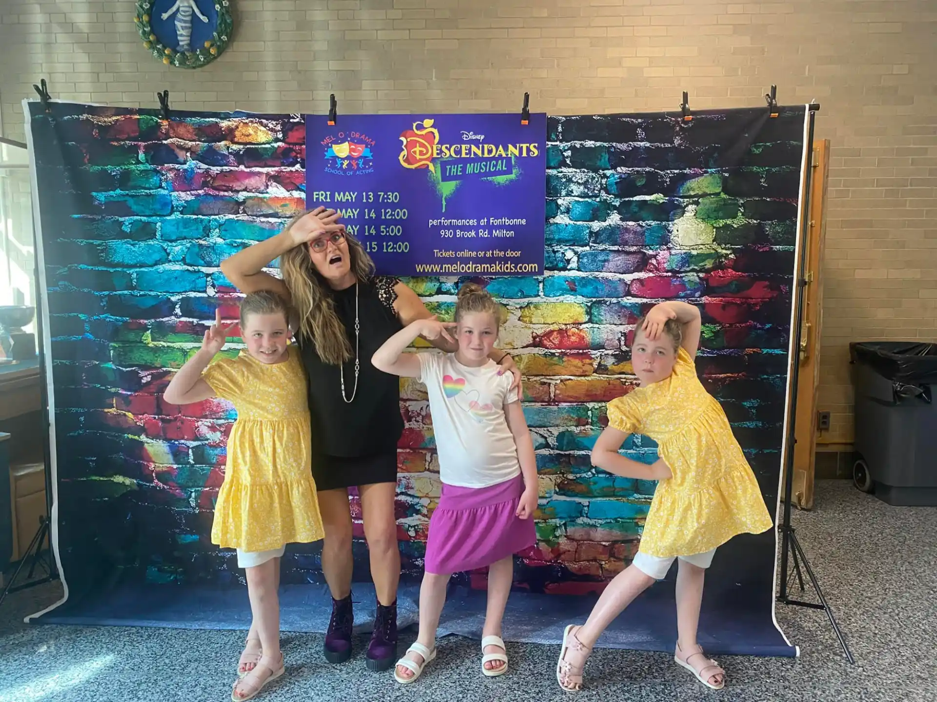 a group of children posing for a photo in front of a chalkboard