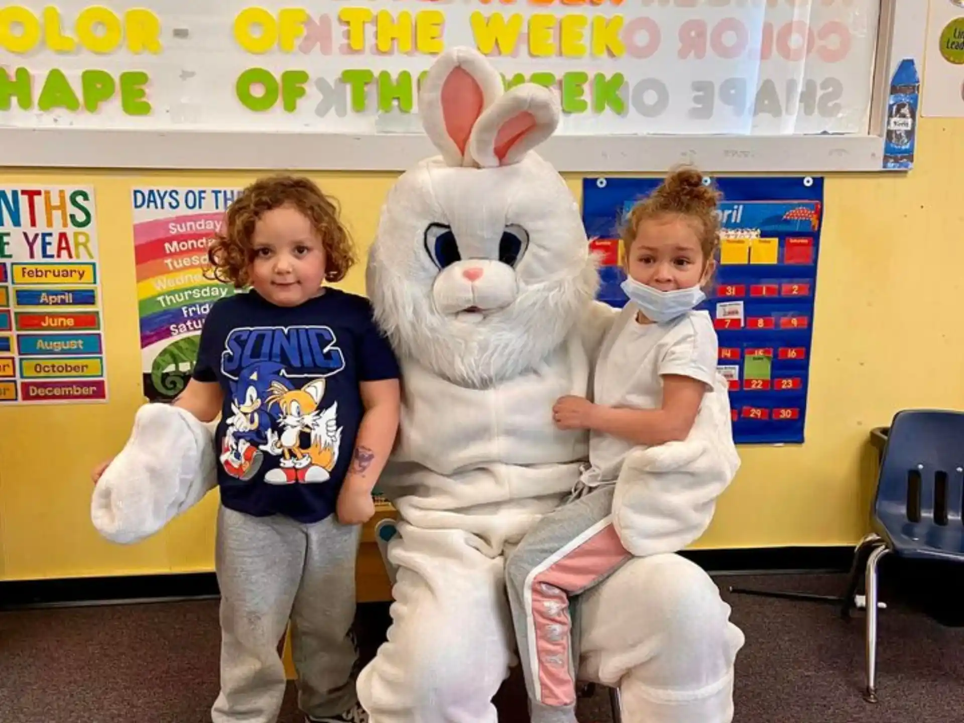 a boy and a girl posing with a person in a rabbit garment