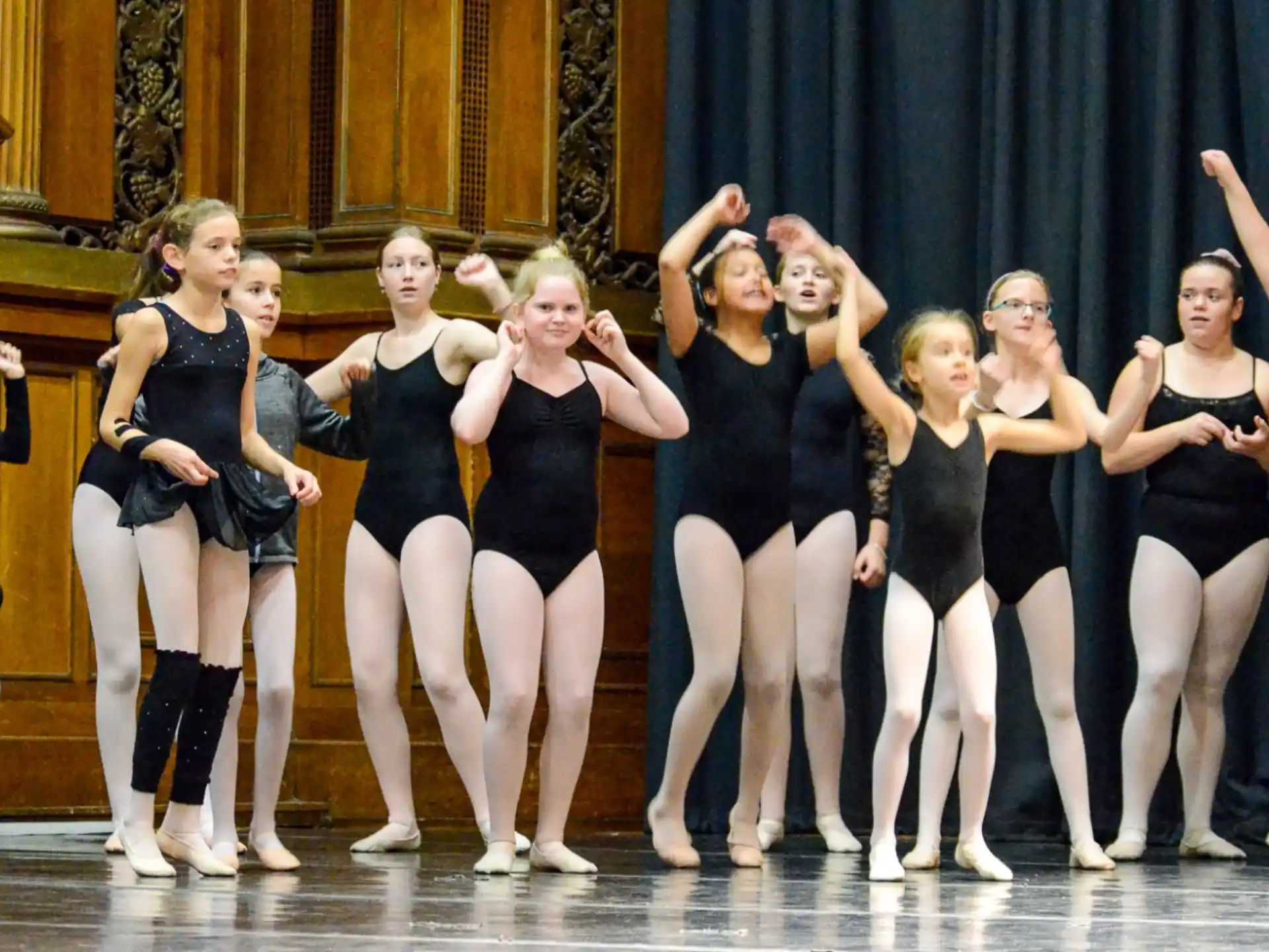 a group of women in black and white dancing on a stage