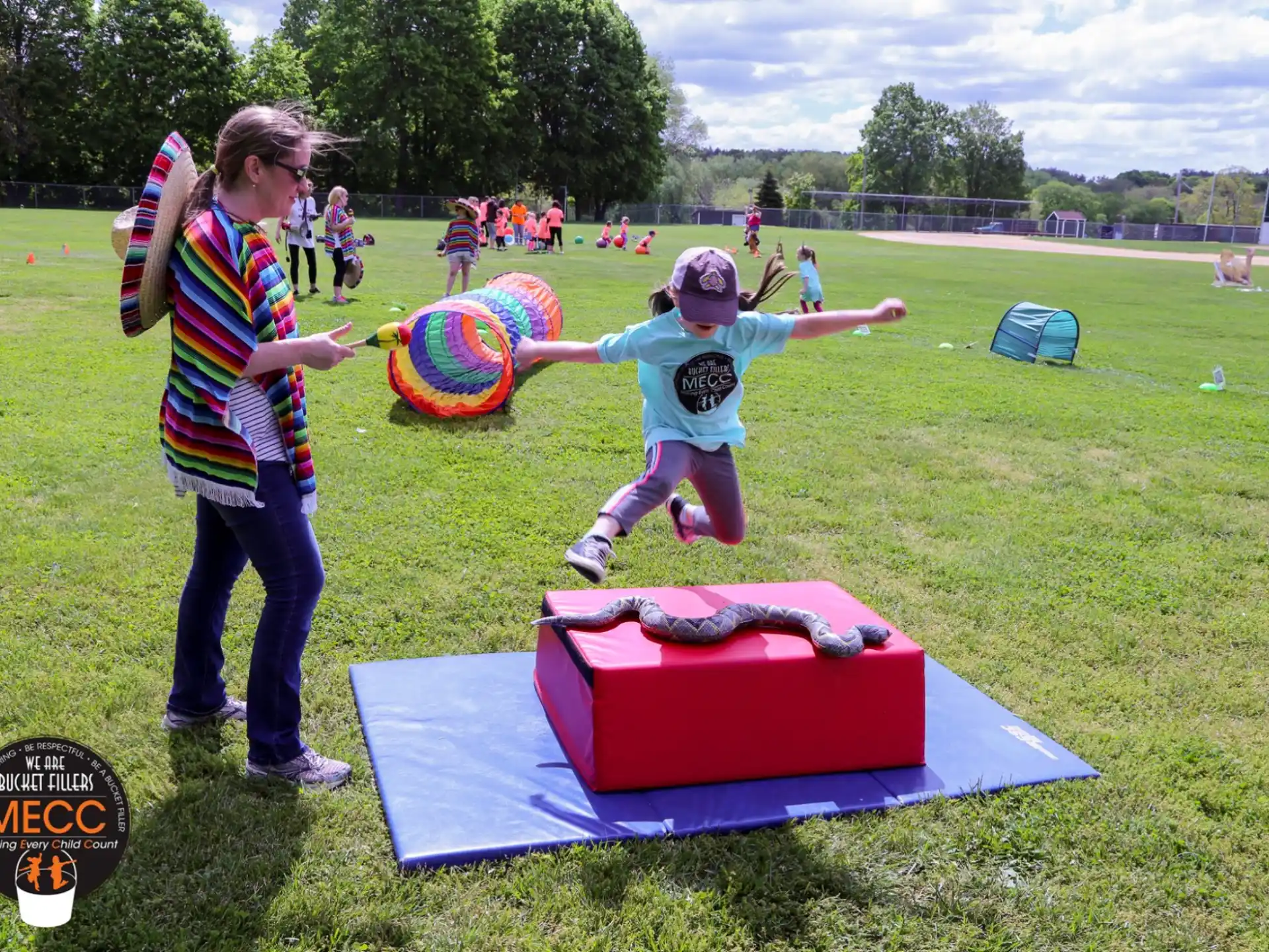 a person and a child playing with a toy in a grassy field