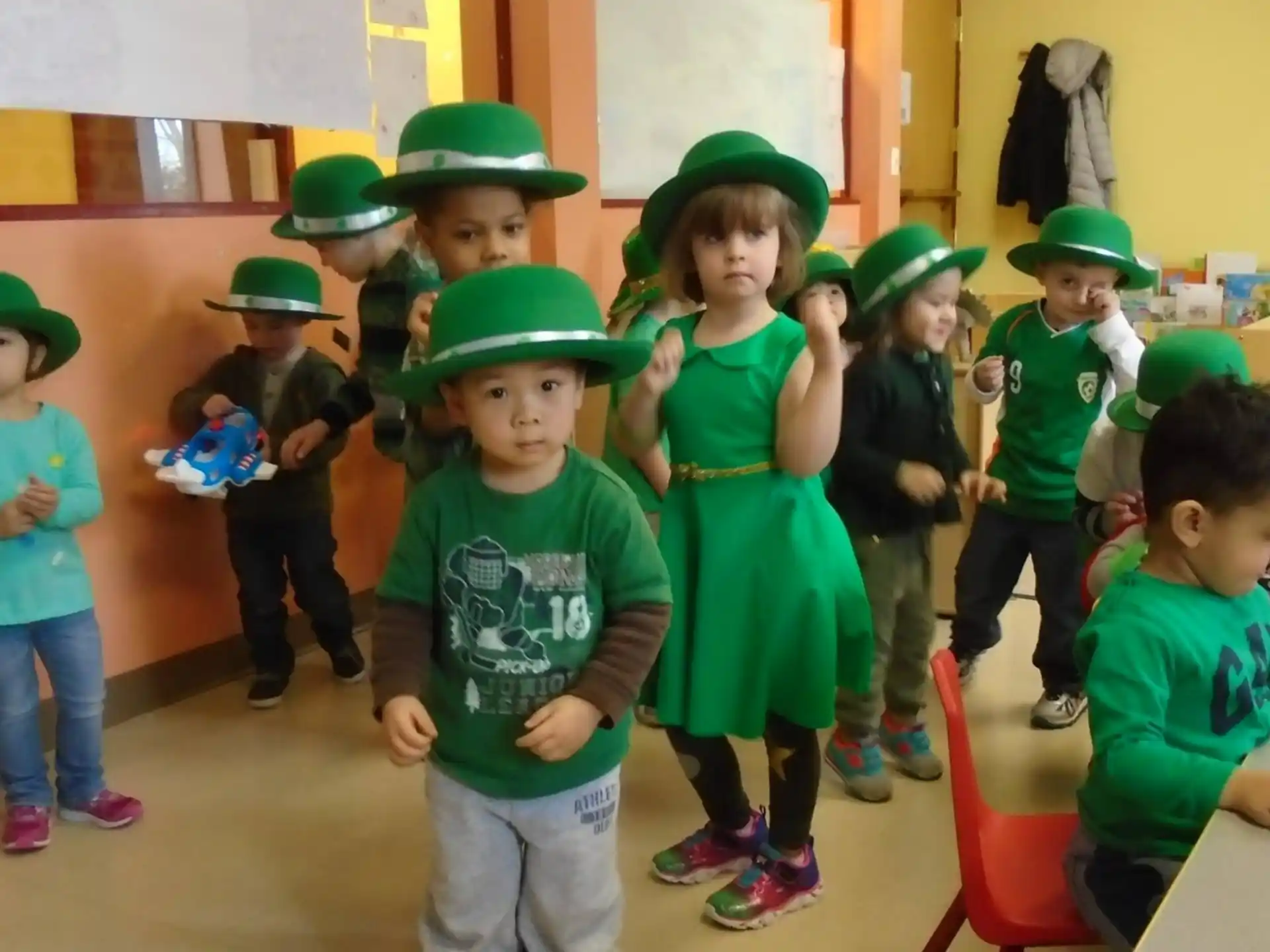 a group of children wearing green hats