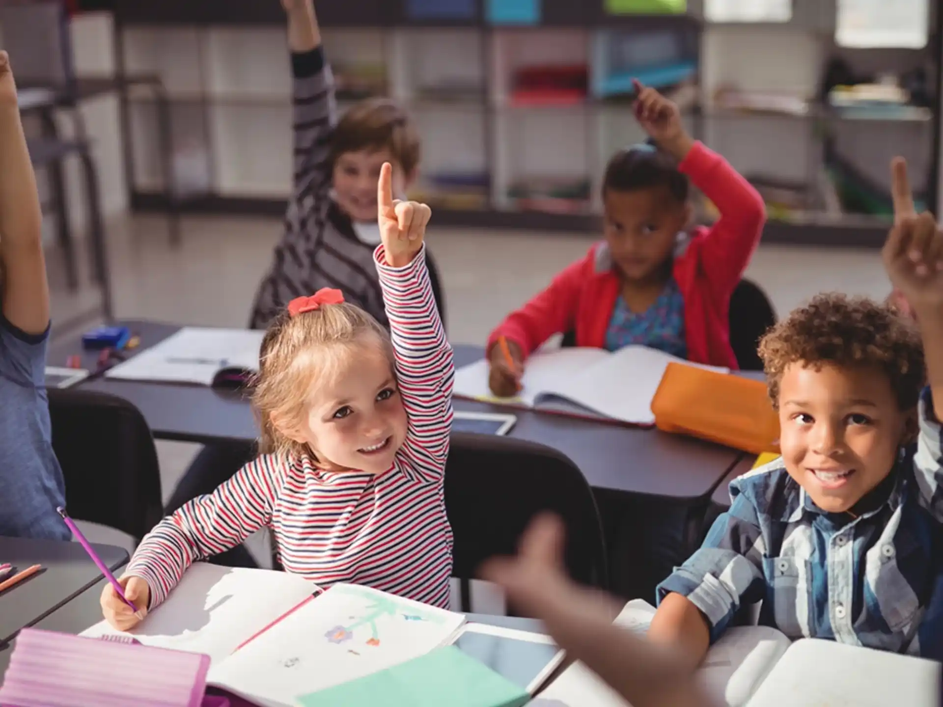 a group of children raising their hands