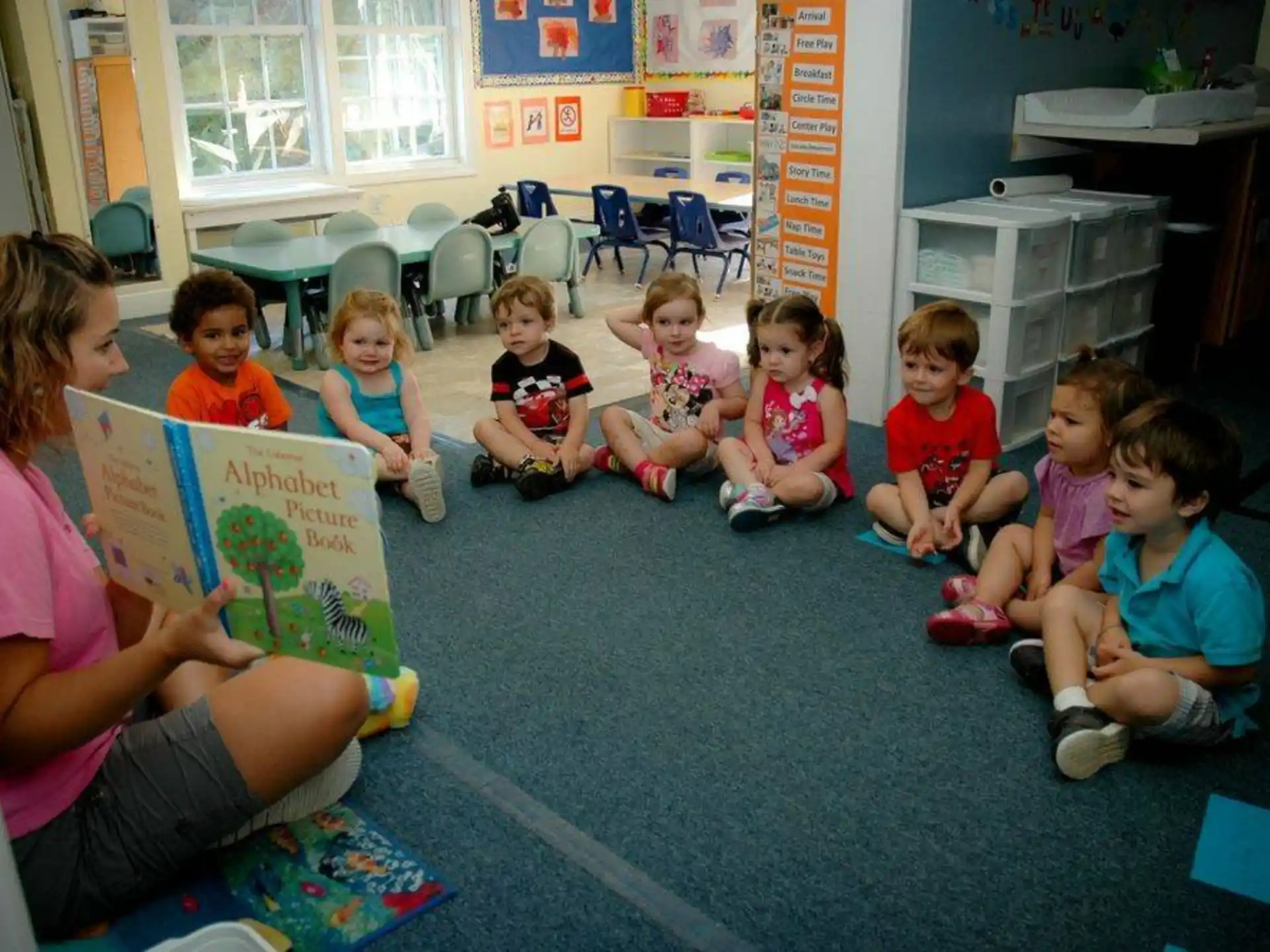 a group of children sitting on the floor reading books