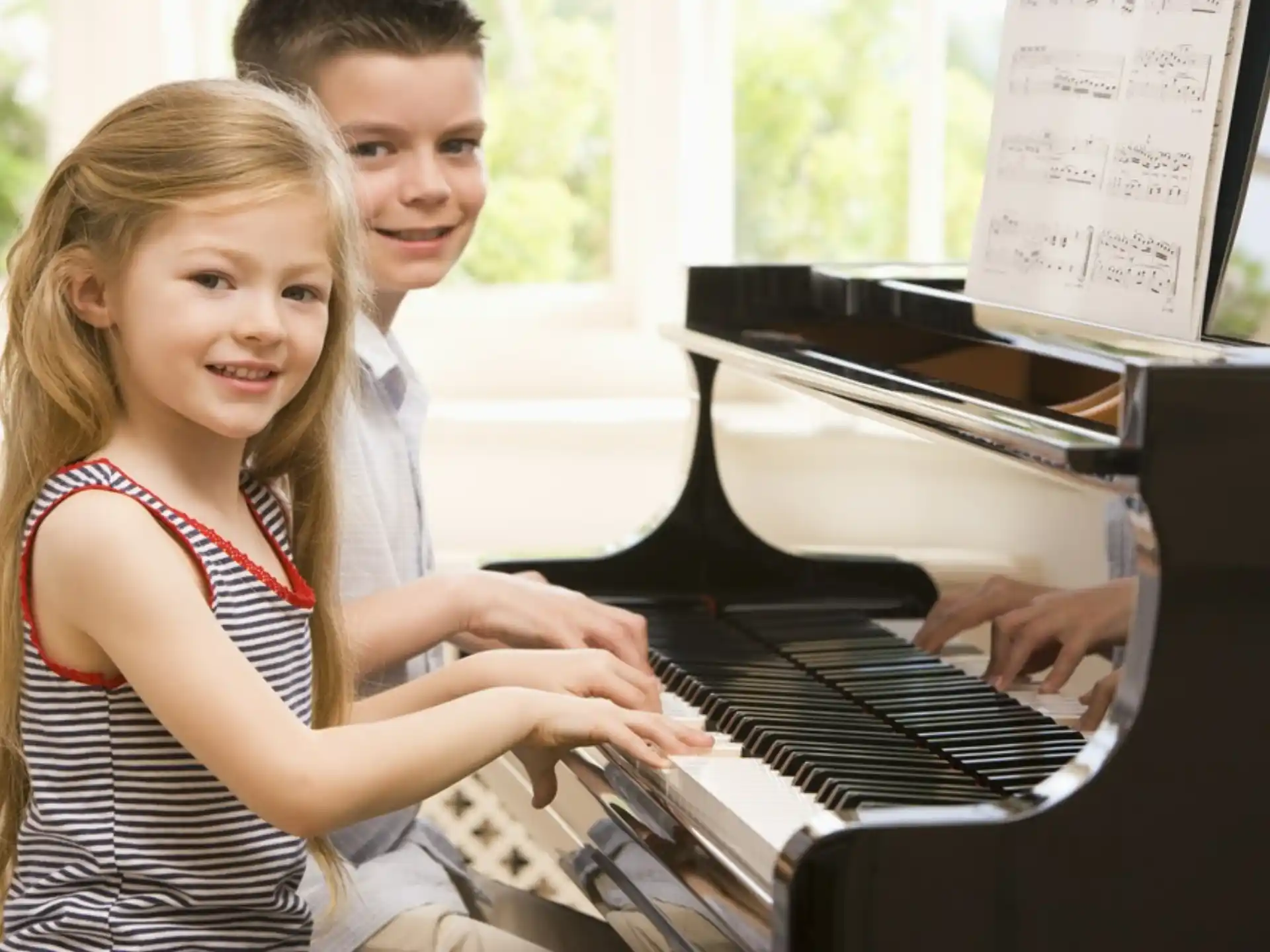 a couple of girls playing piano