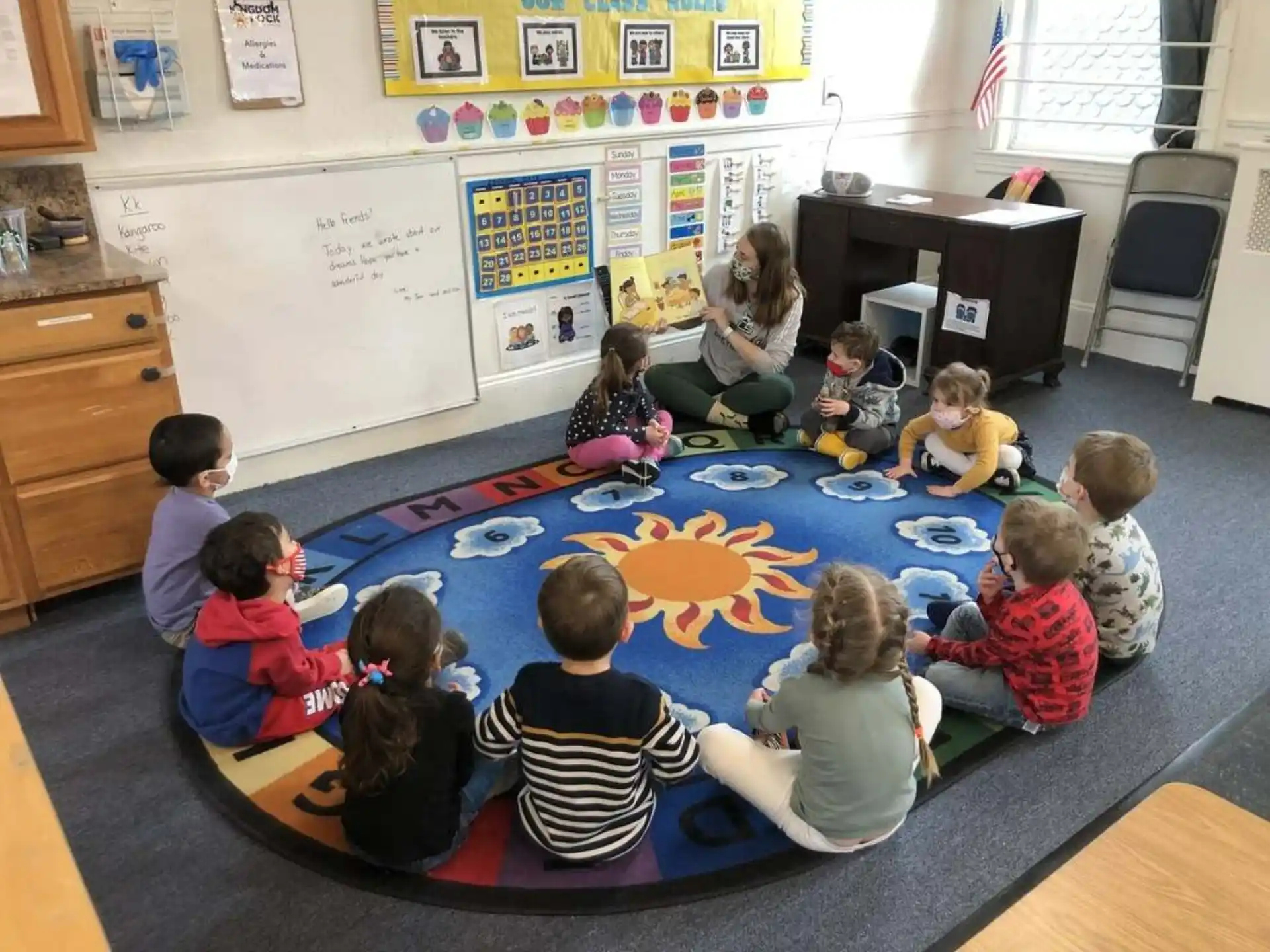 a group of children sitting on the floor in a classroom