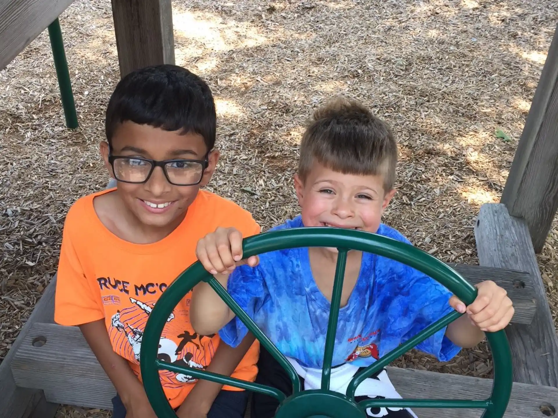 two boys sitting in a playground ride