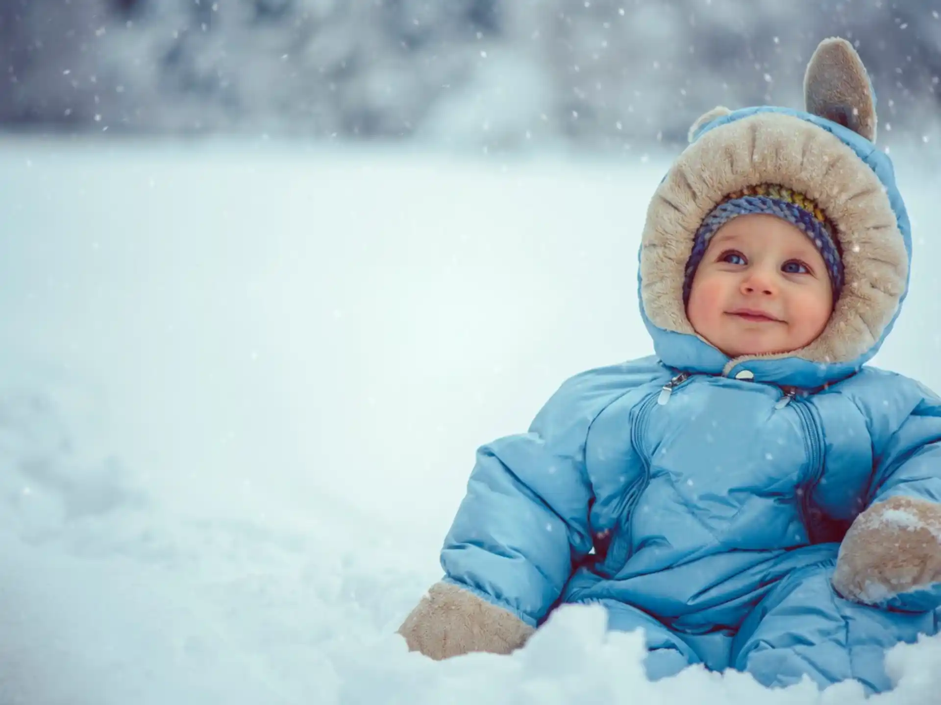 a baby in a blue coat in the snow