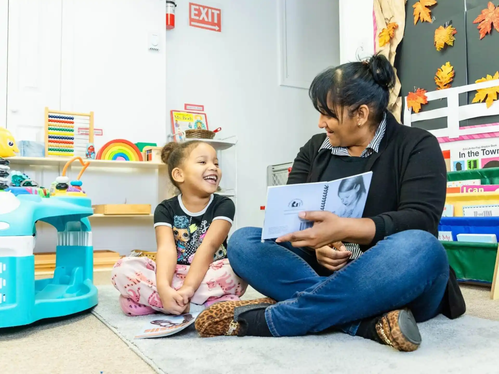 a person reading a book to a young girl