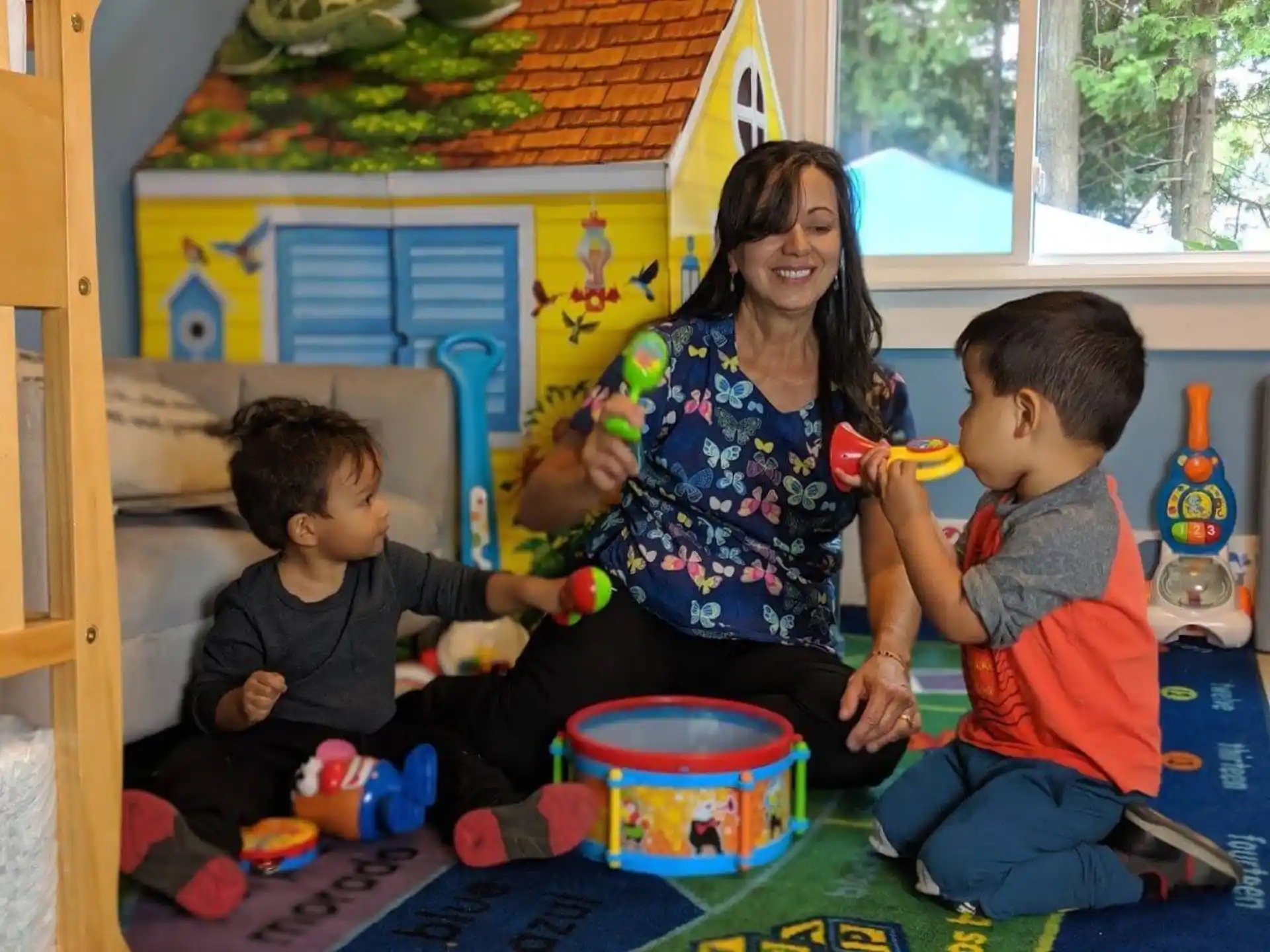 a person and two children playing with toys on the floor