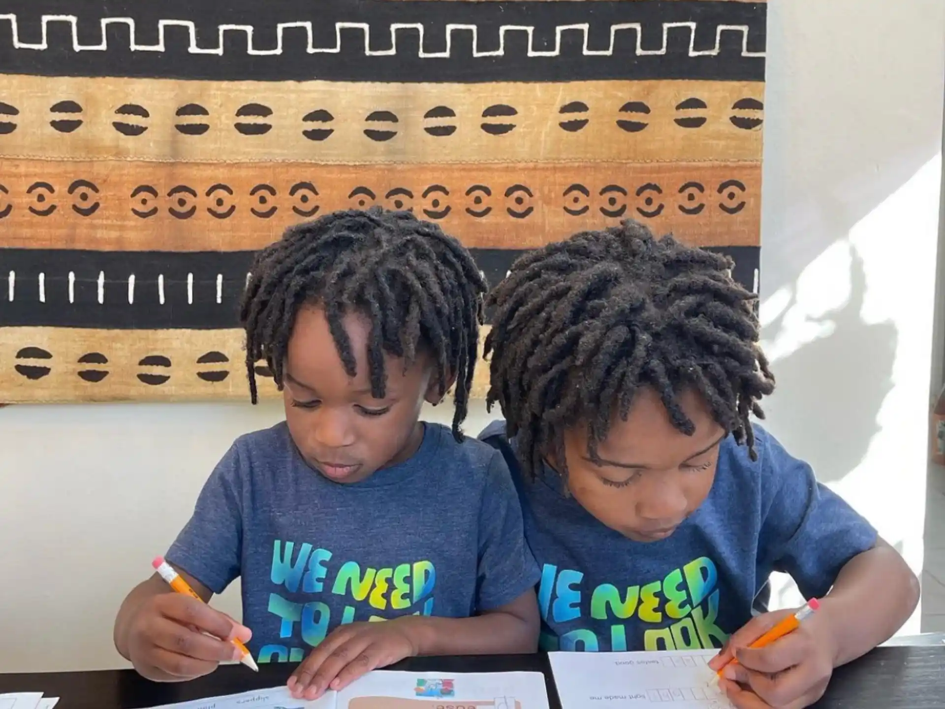 a few young boys writing on paper