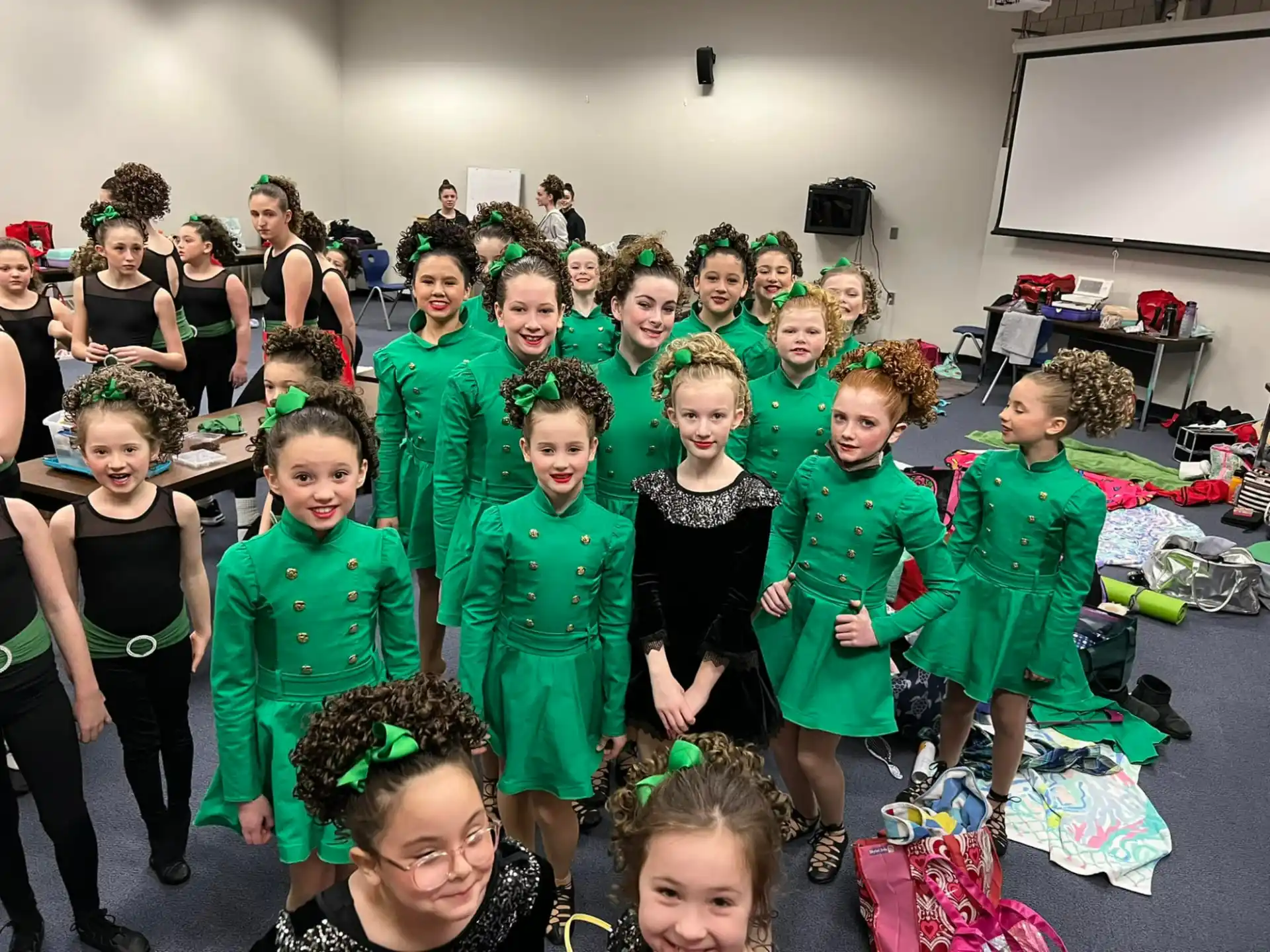 a group of children in green and black clothing