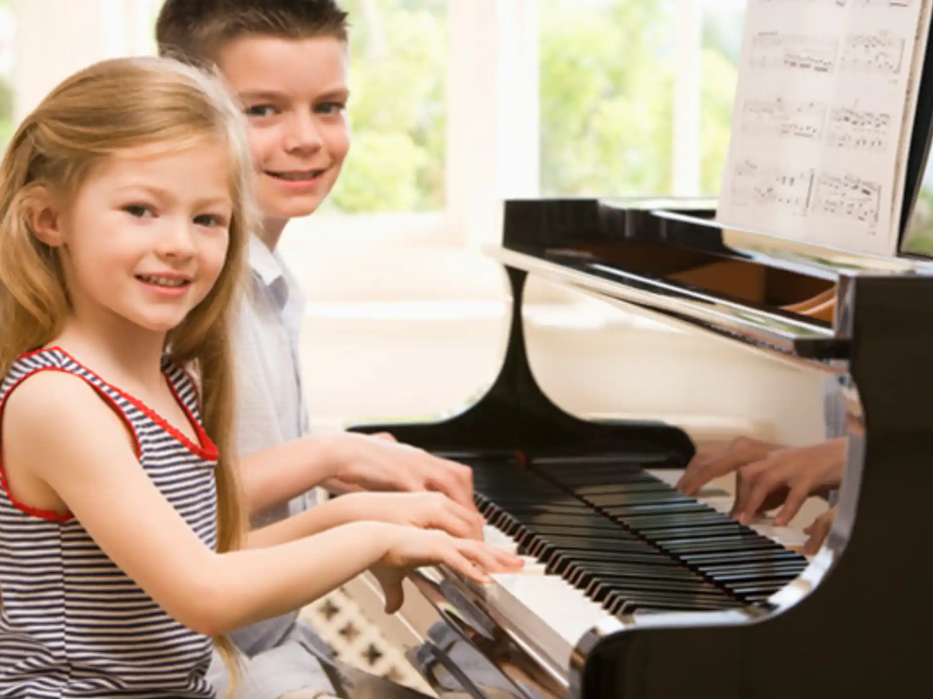 a couple of girls playing piano