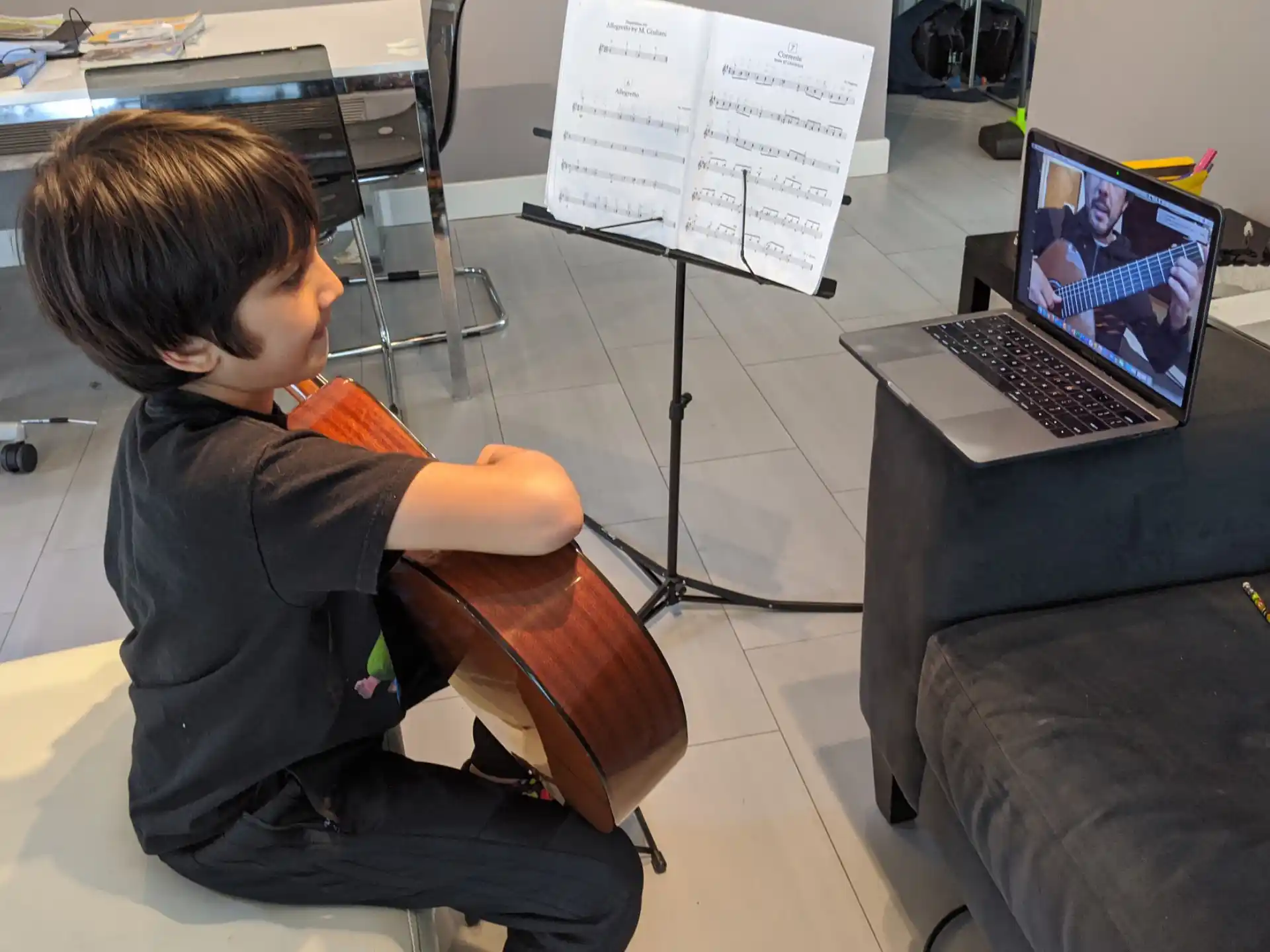 a boy sitting in front of a laptop