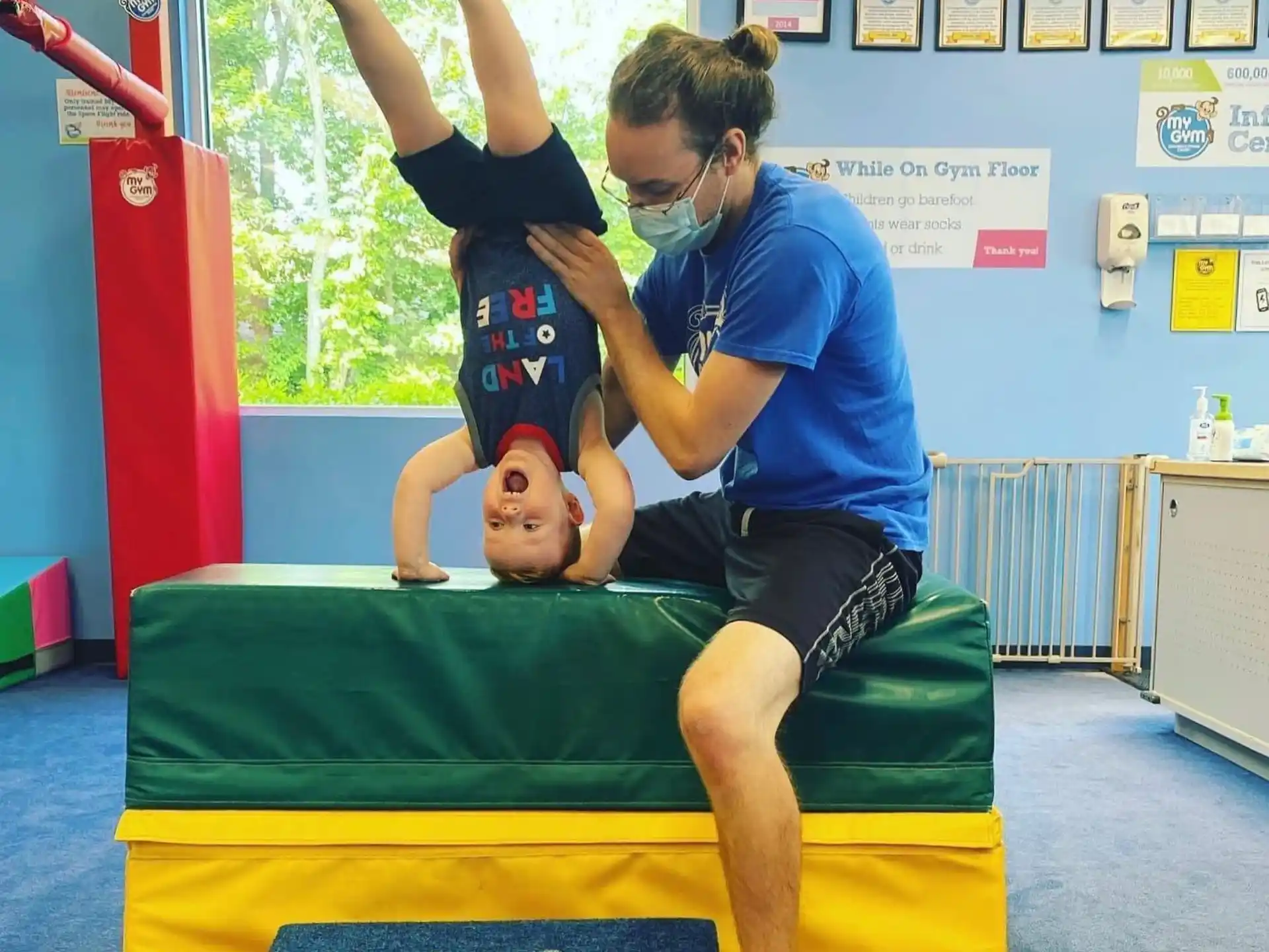 a person holding a baby on a trampoline