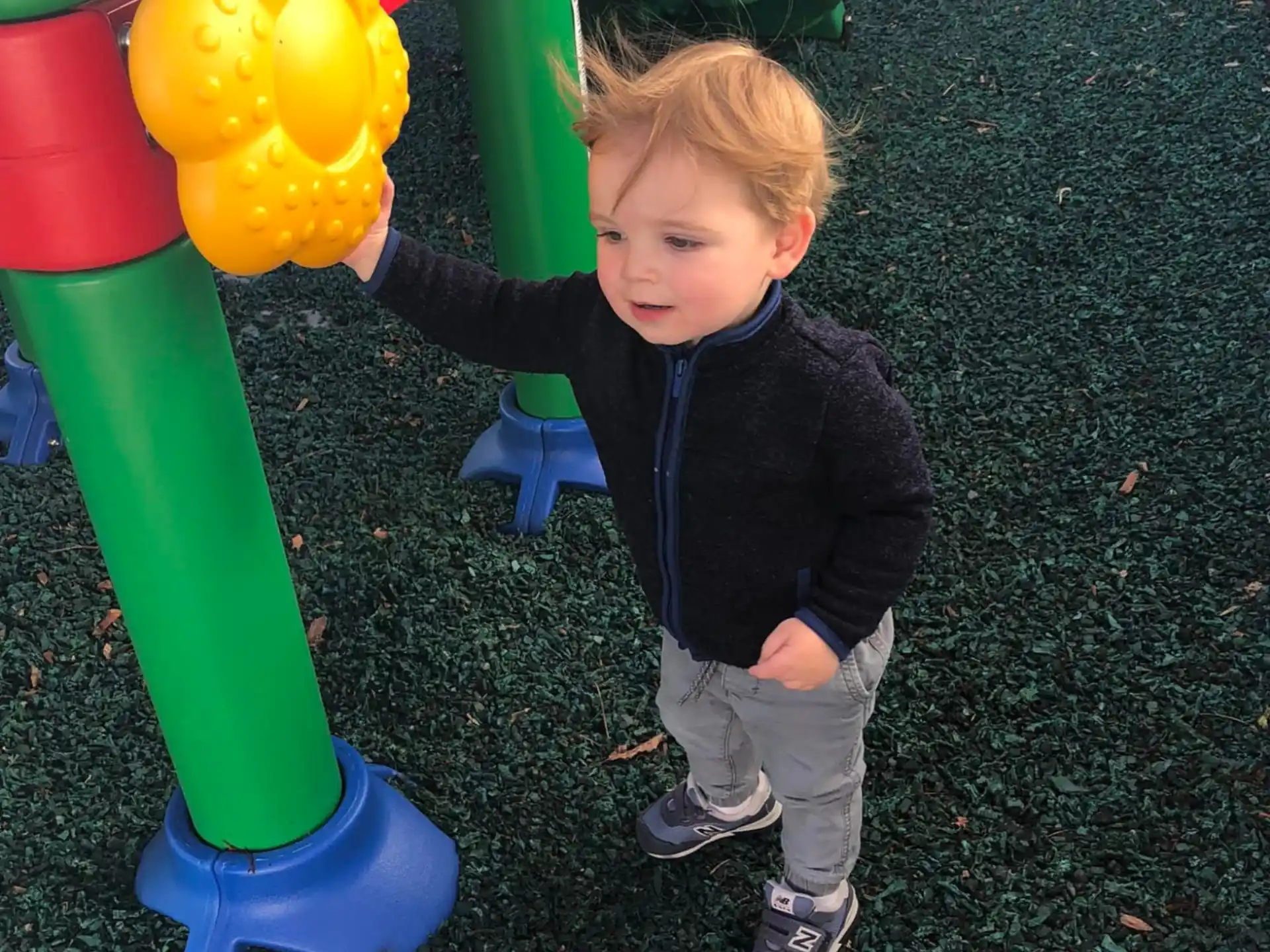 a child standing next to a toy