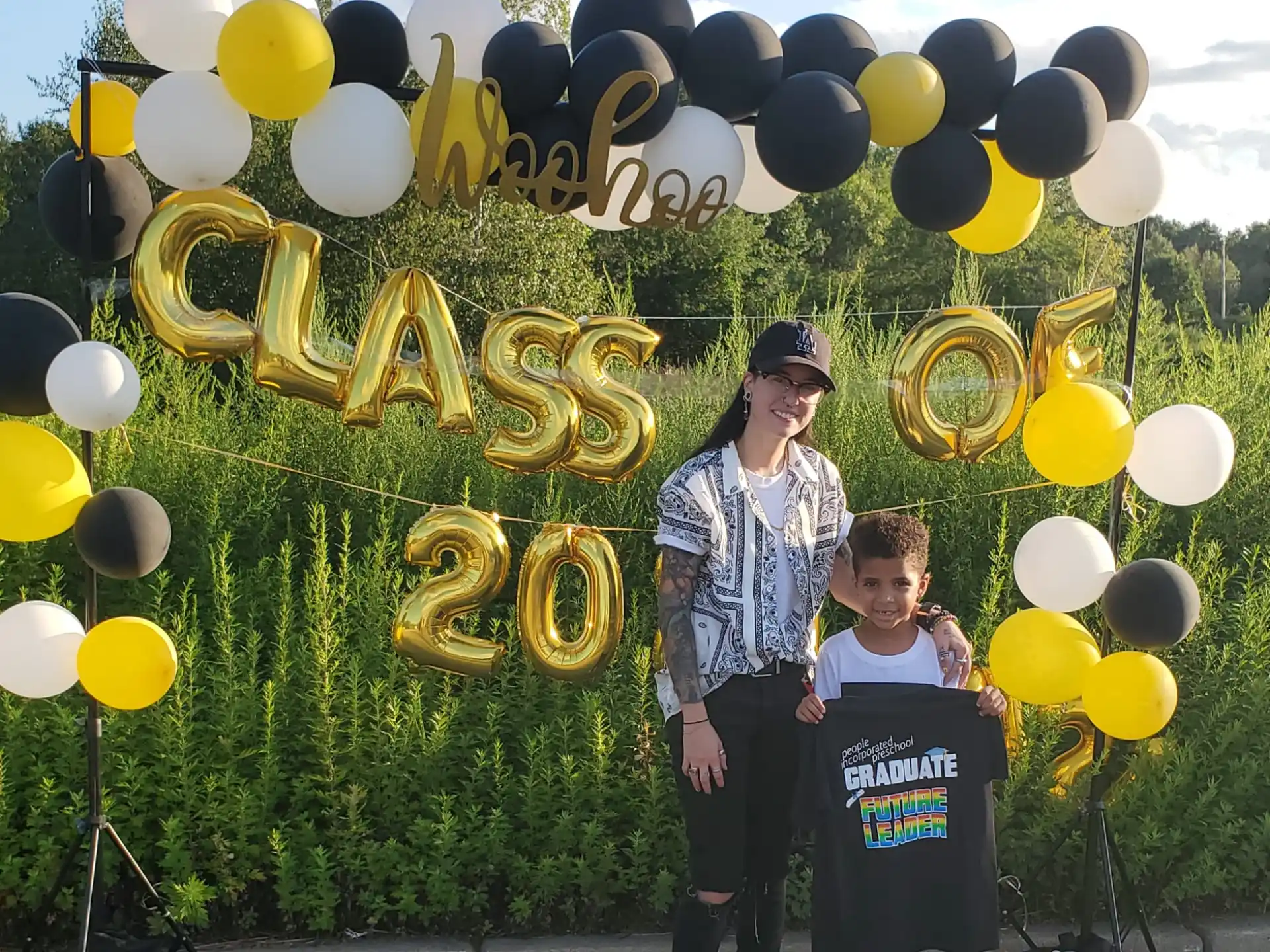 a man and a woman posing with a large group of balloons