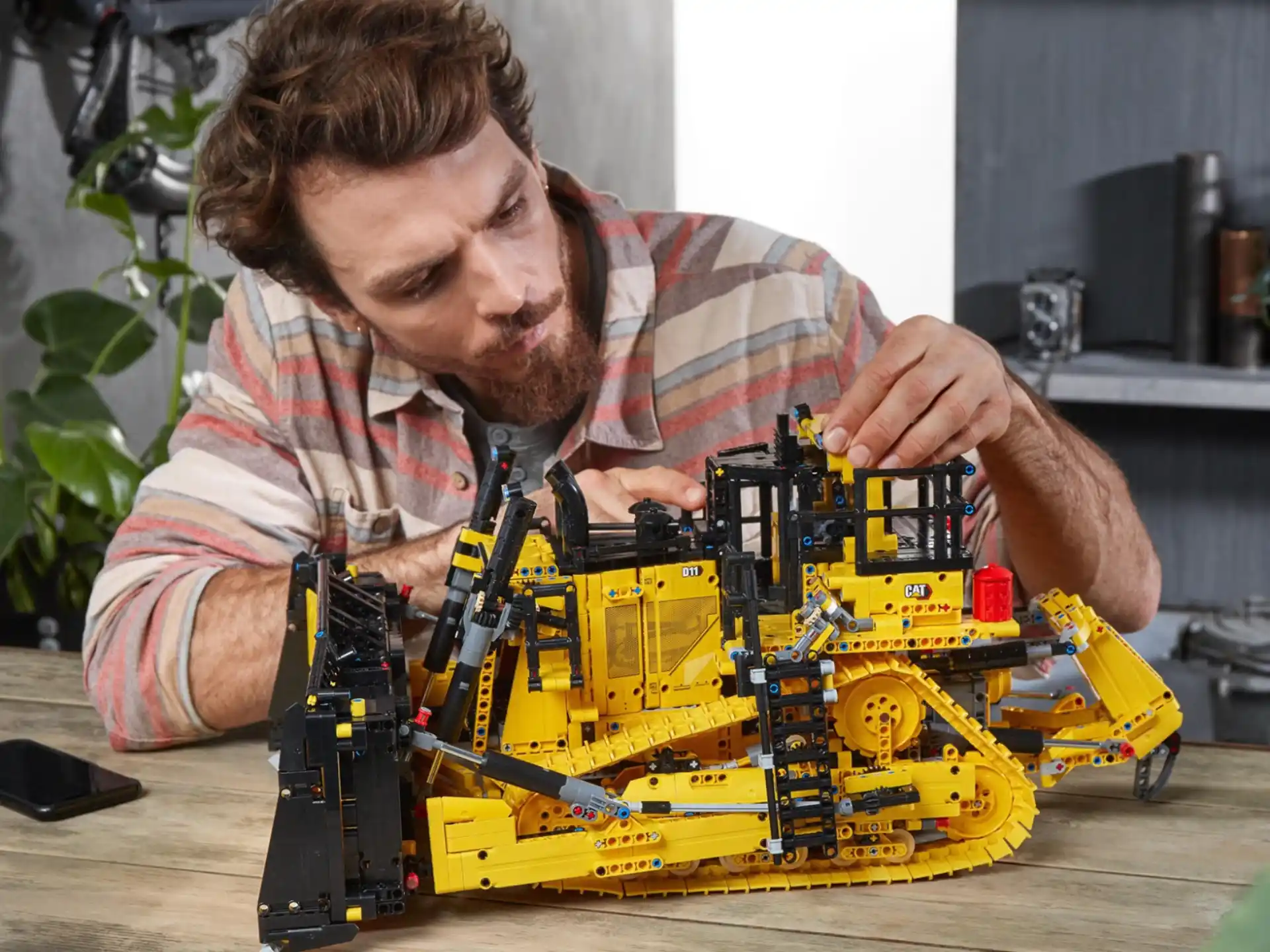 a man sitting at a table with a toy train