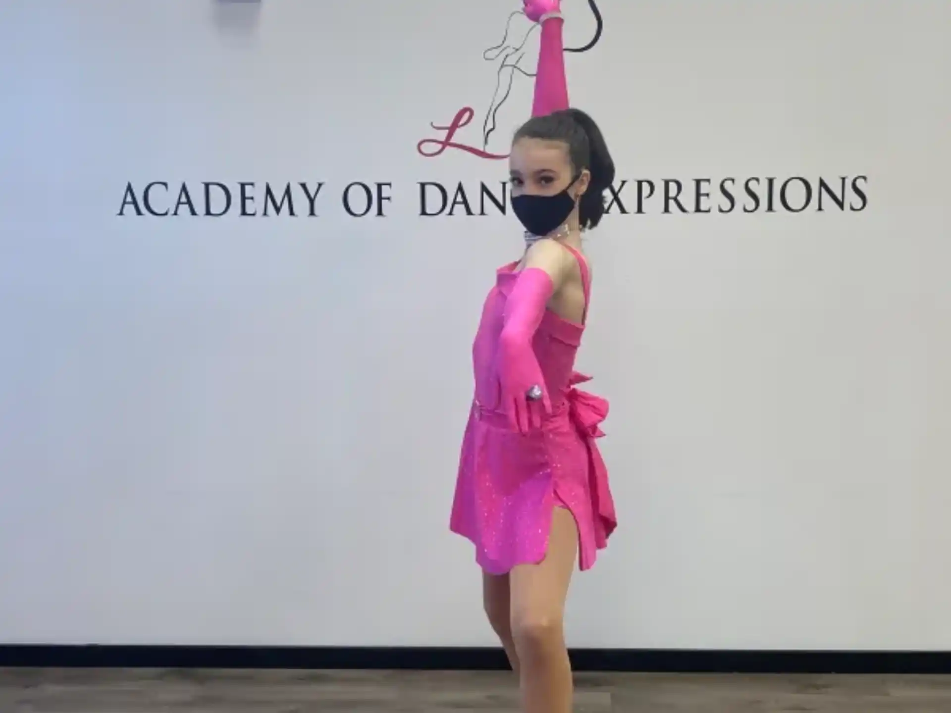 a girl wearing a pink dress and holding a wand