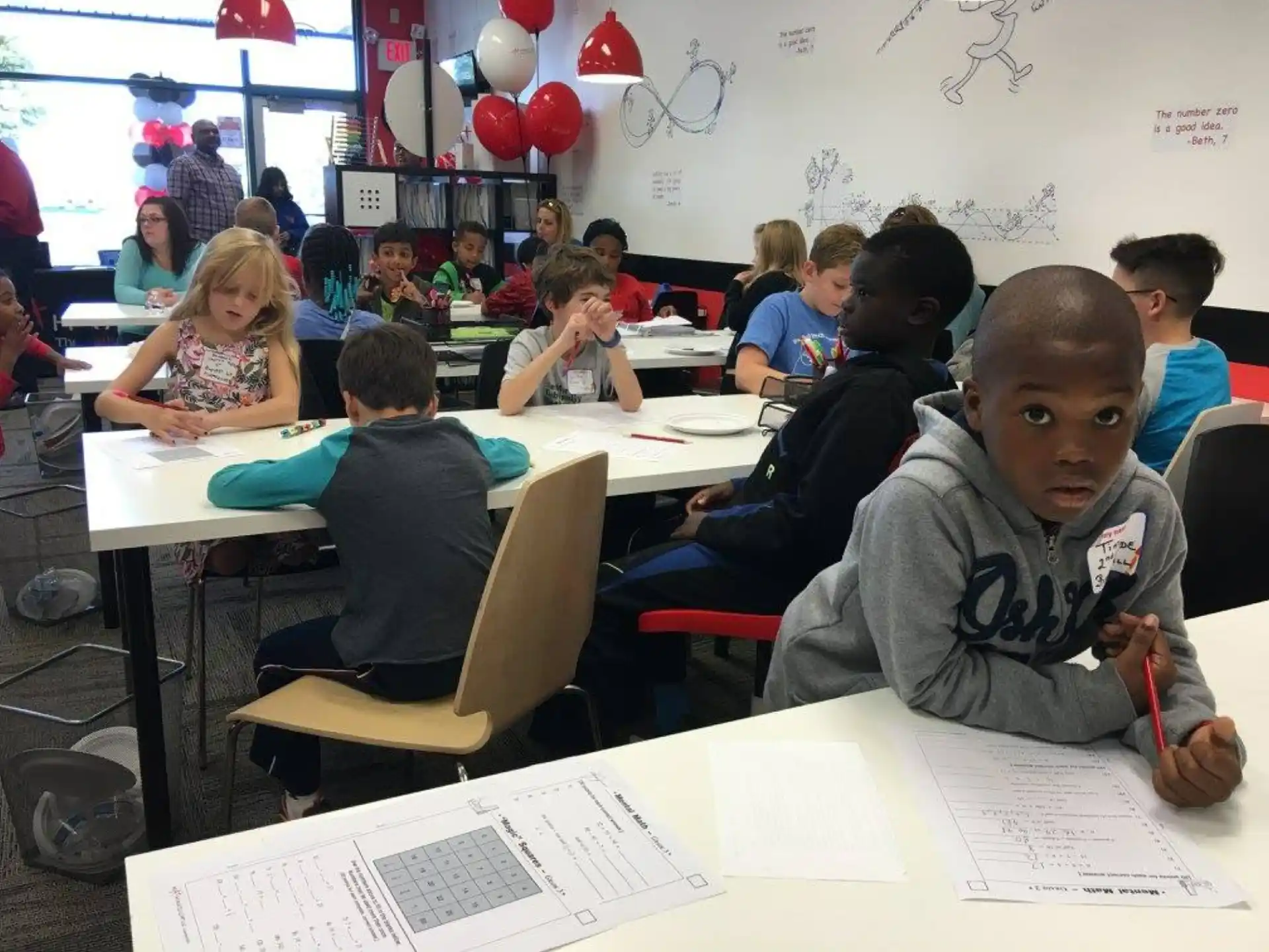 a group of children sitting at desks in a classroom