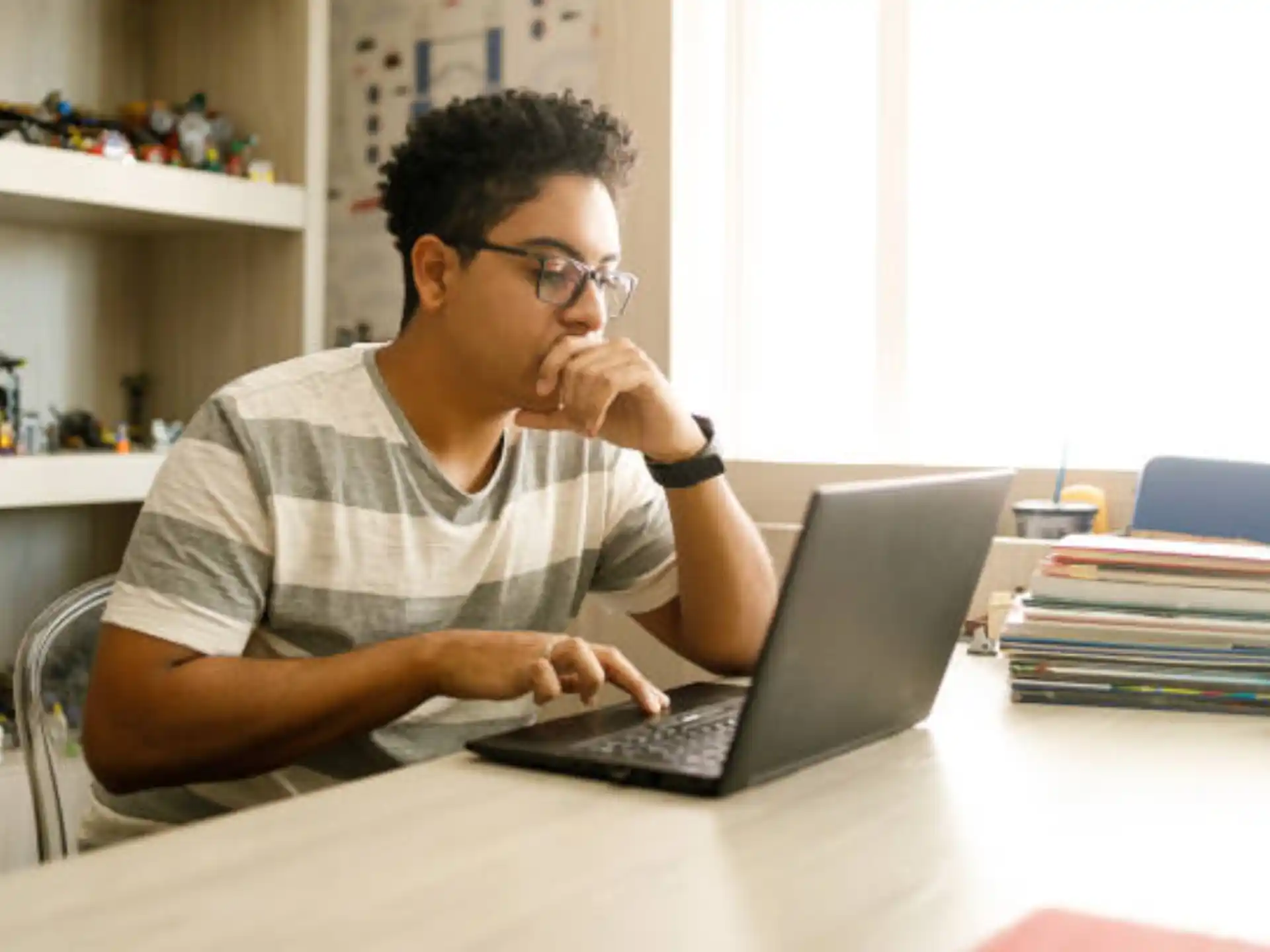 a man sitting at a table using a laptop