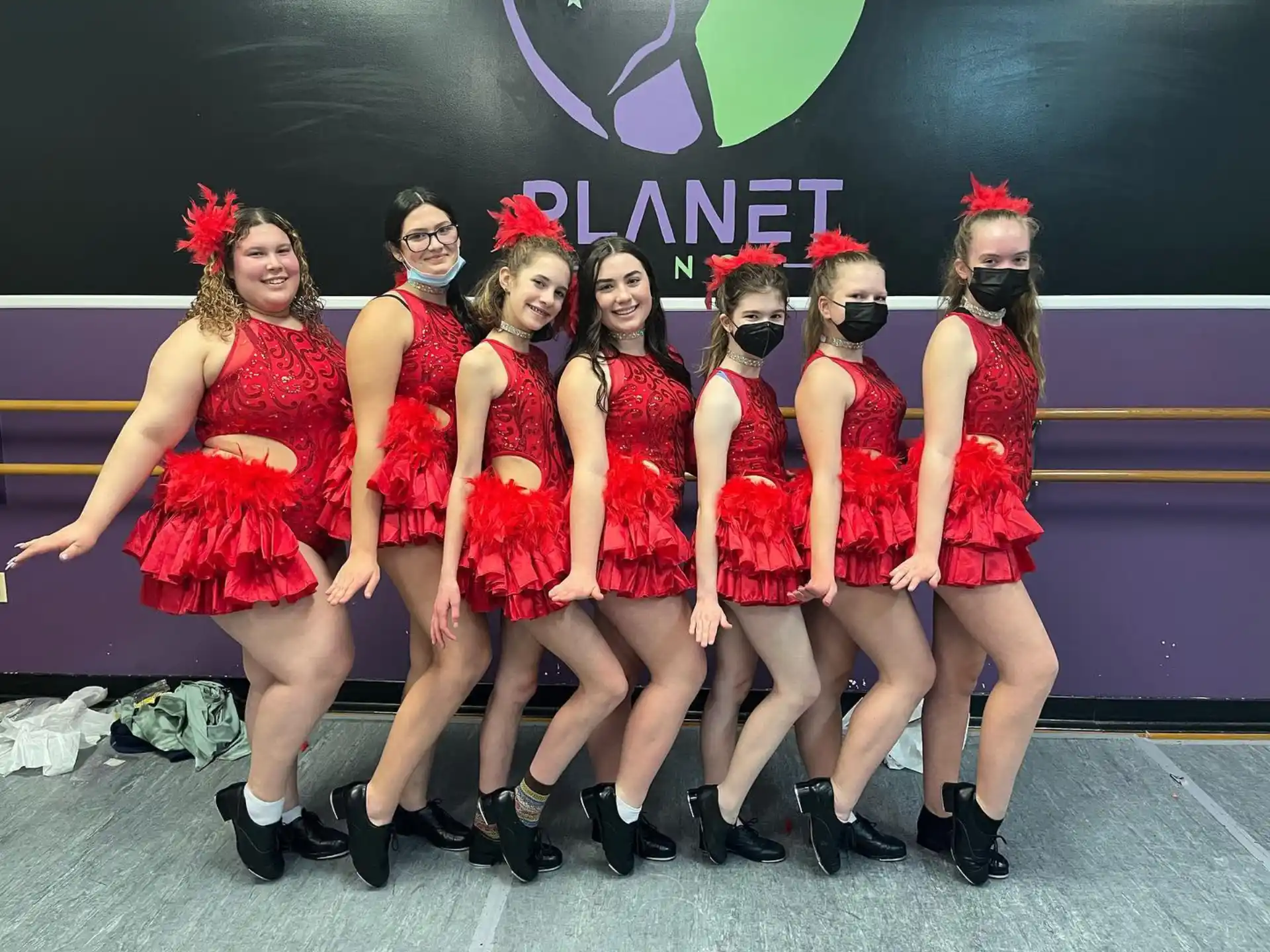 a group of women in red dresses