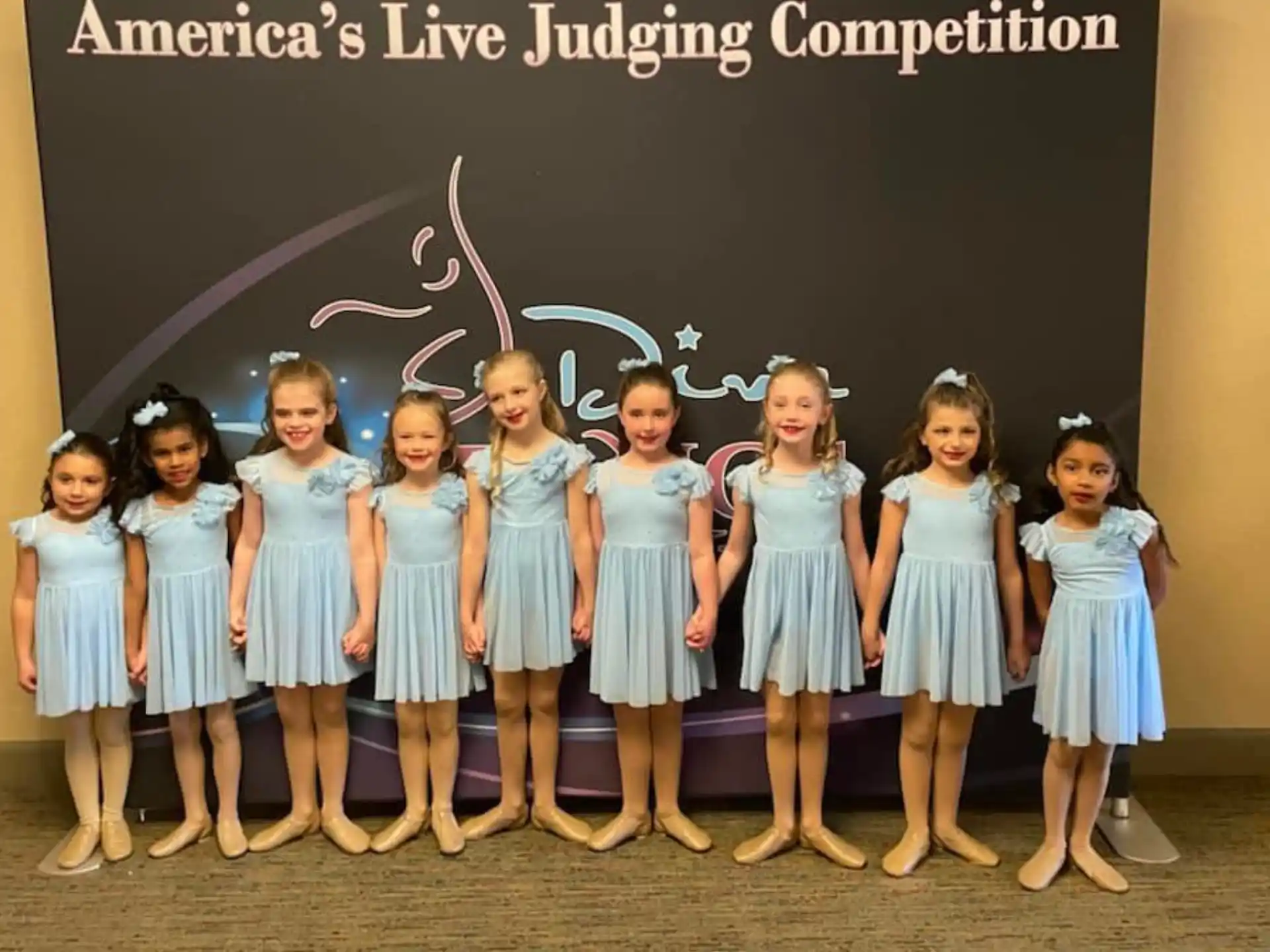 a group of girls in blue dresses