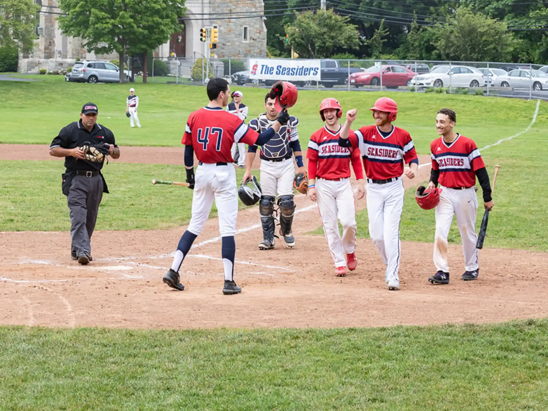 a group of baseball players walk across a field