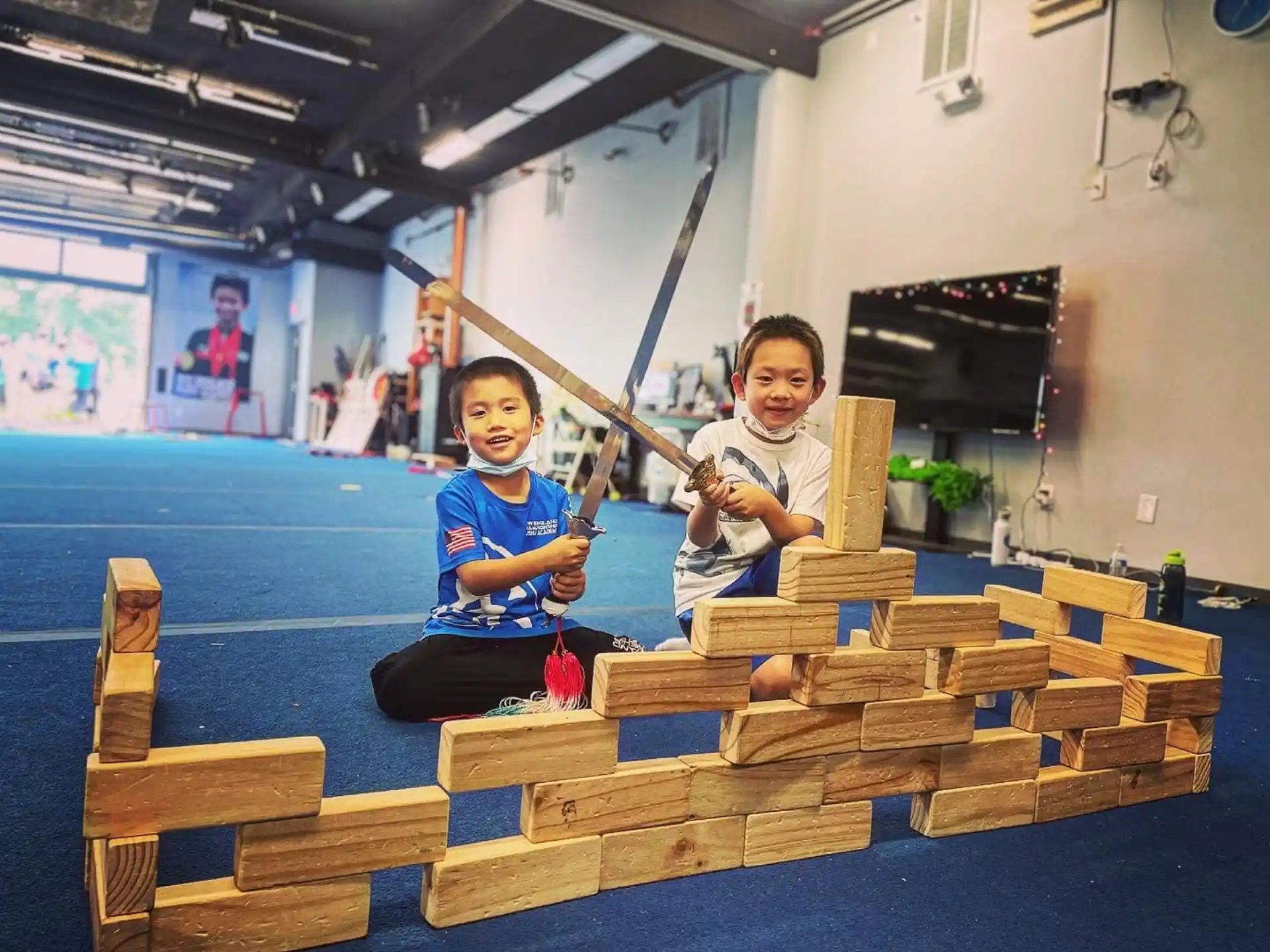 two kids sitting on a wood structure