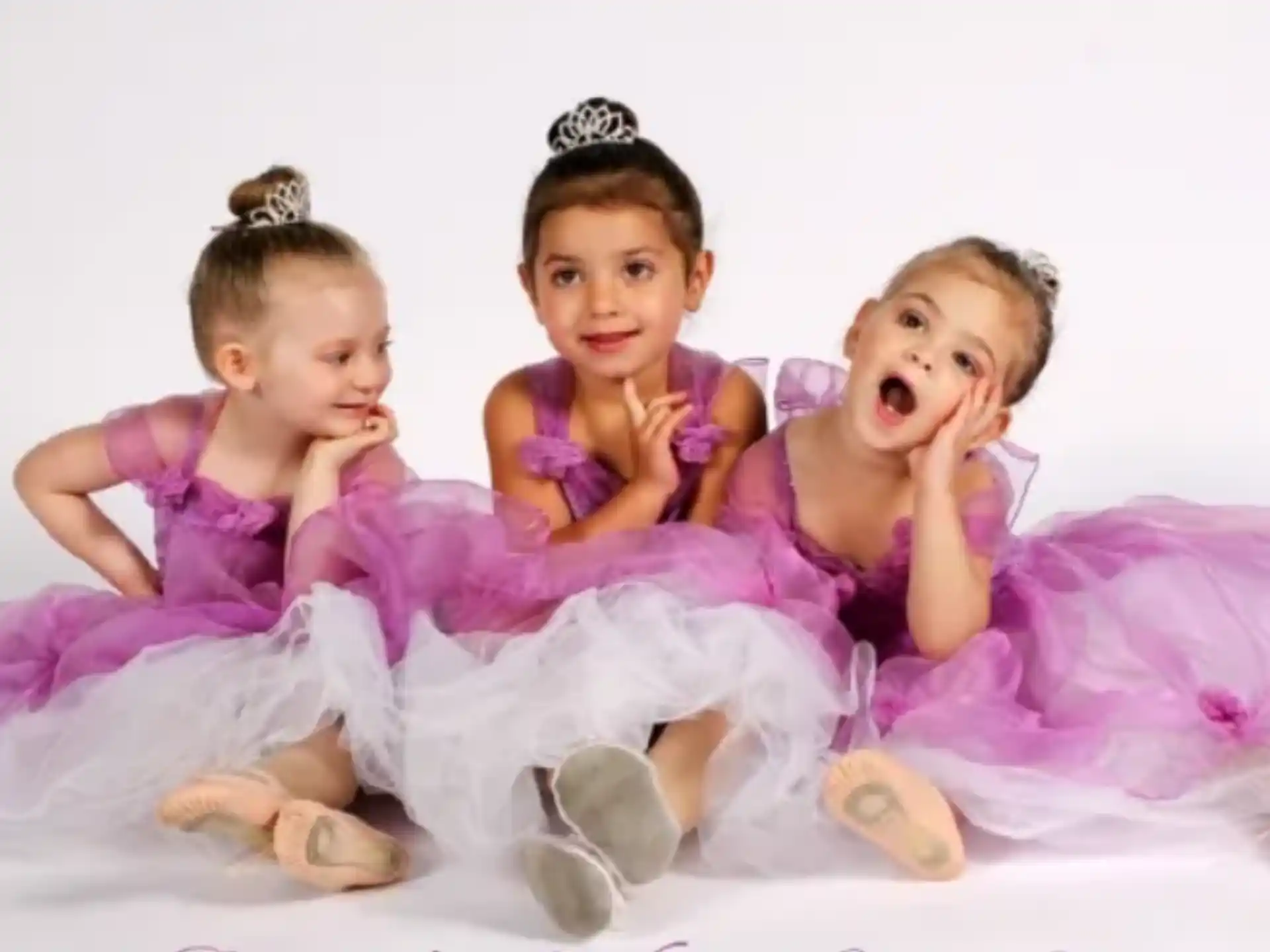 a group of girls in pink dresses
