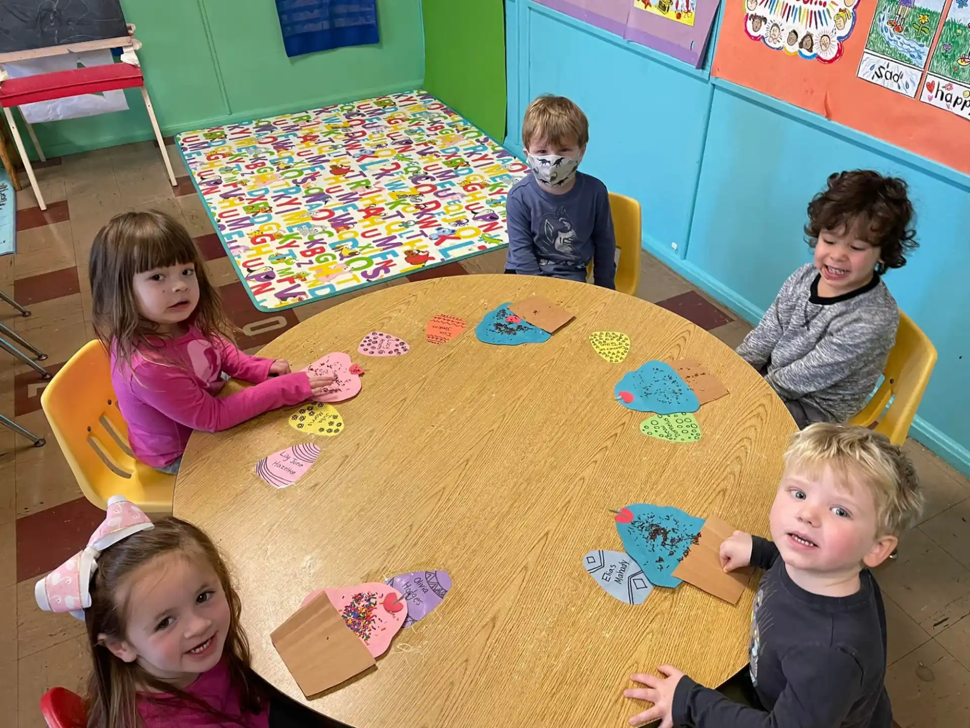 a group of children sitting around a table with a paper on it