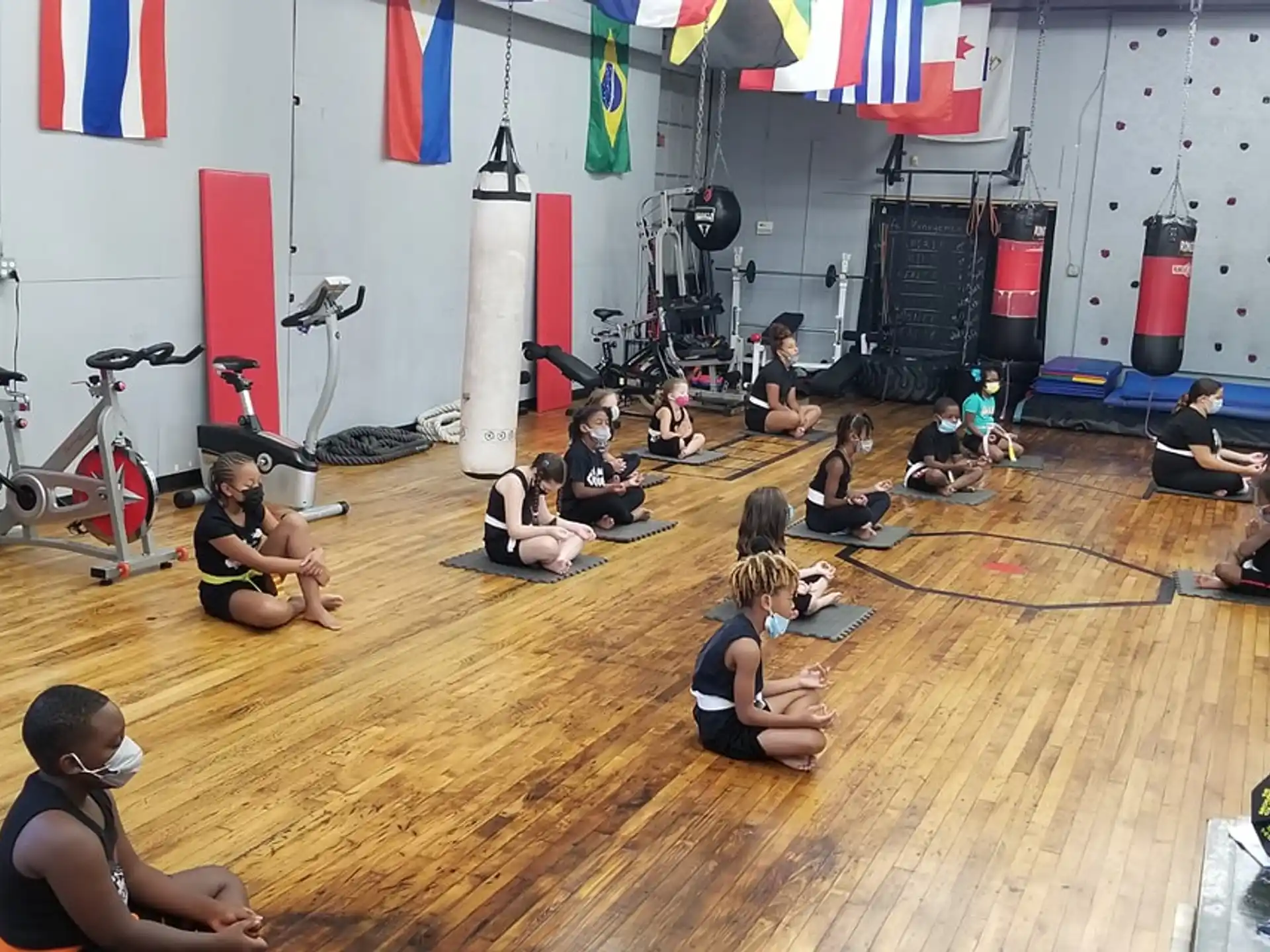 a group of people sitting on the floor in a room with a wood floor and a wood floor