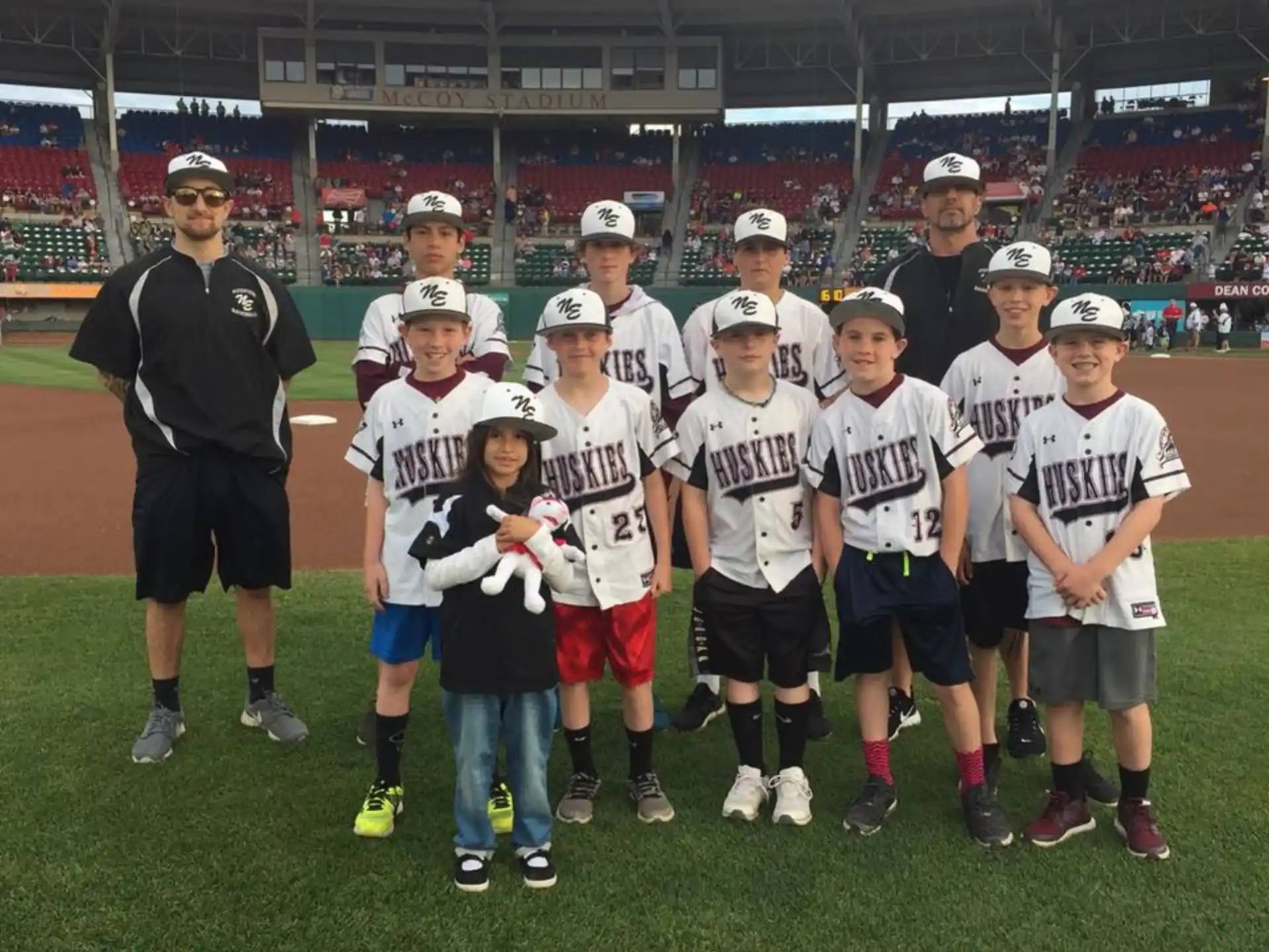 a group of boys wearing white shirts and standing on a field