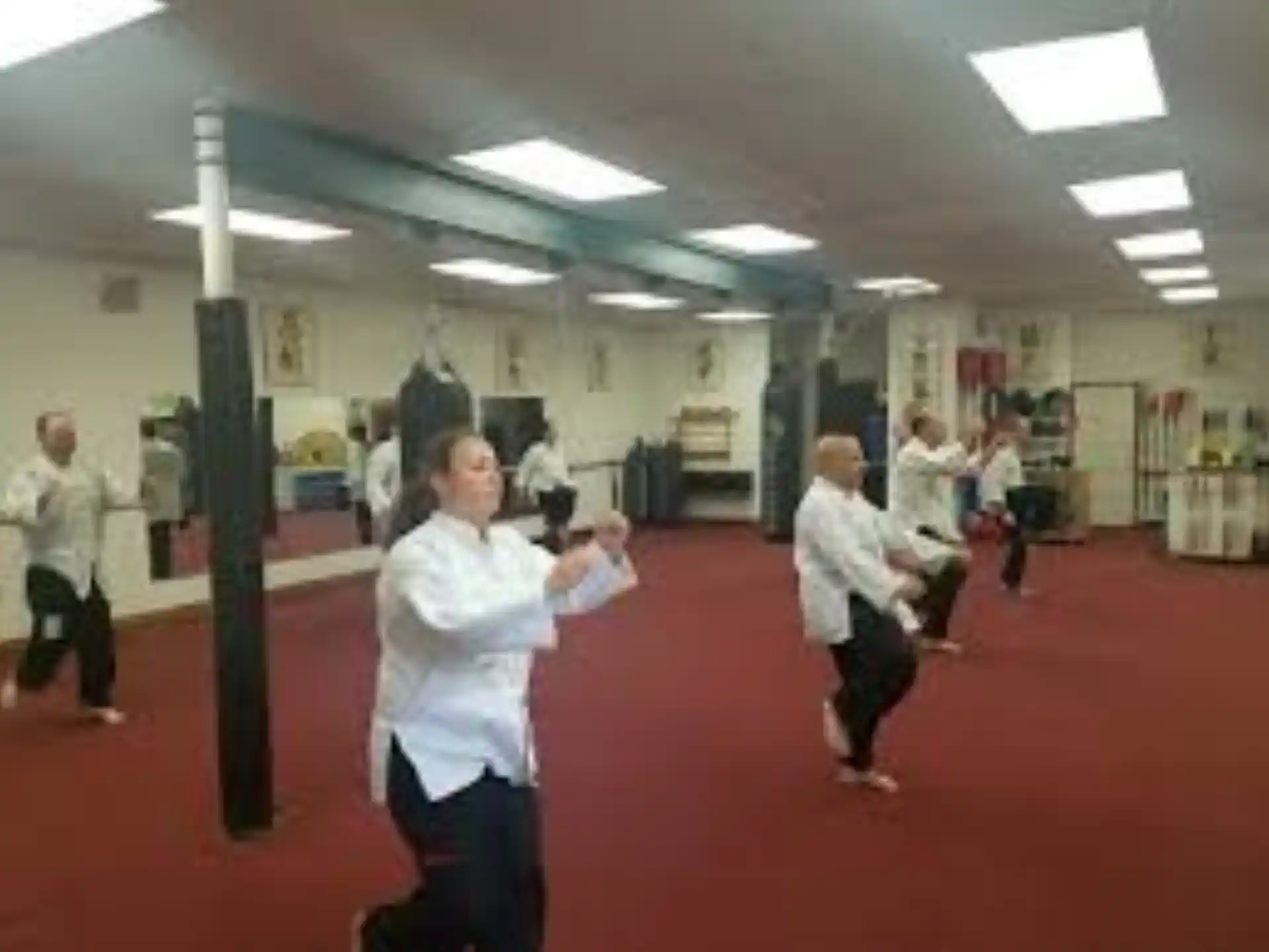 a group of people dancing in a room with bookshelves