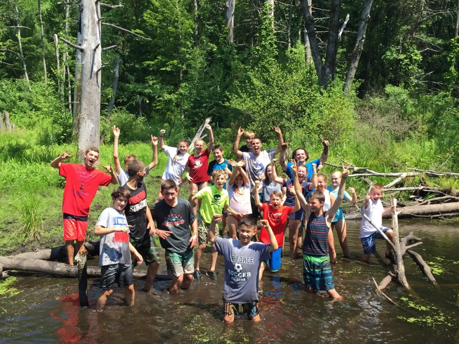 a group of people posing for a photo in a stream