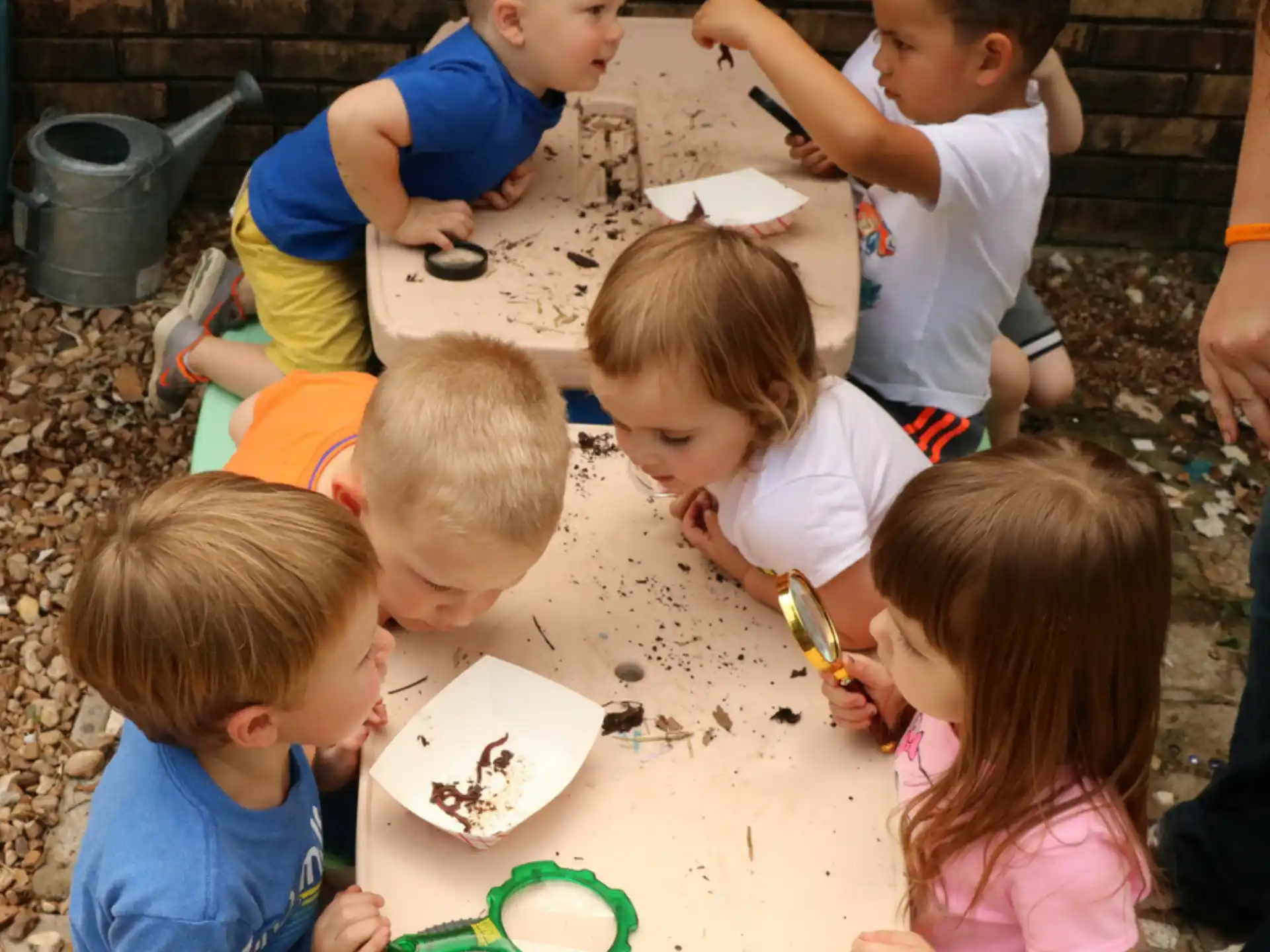 a group of children sitting around a table eating food