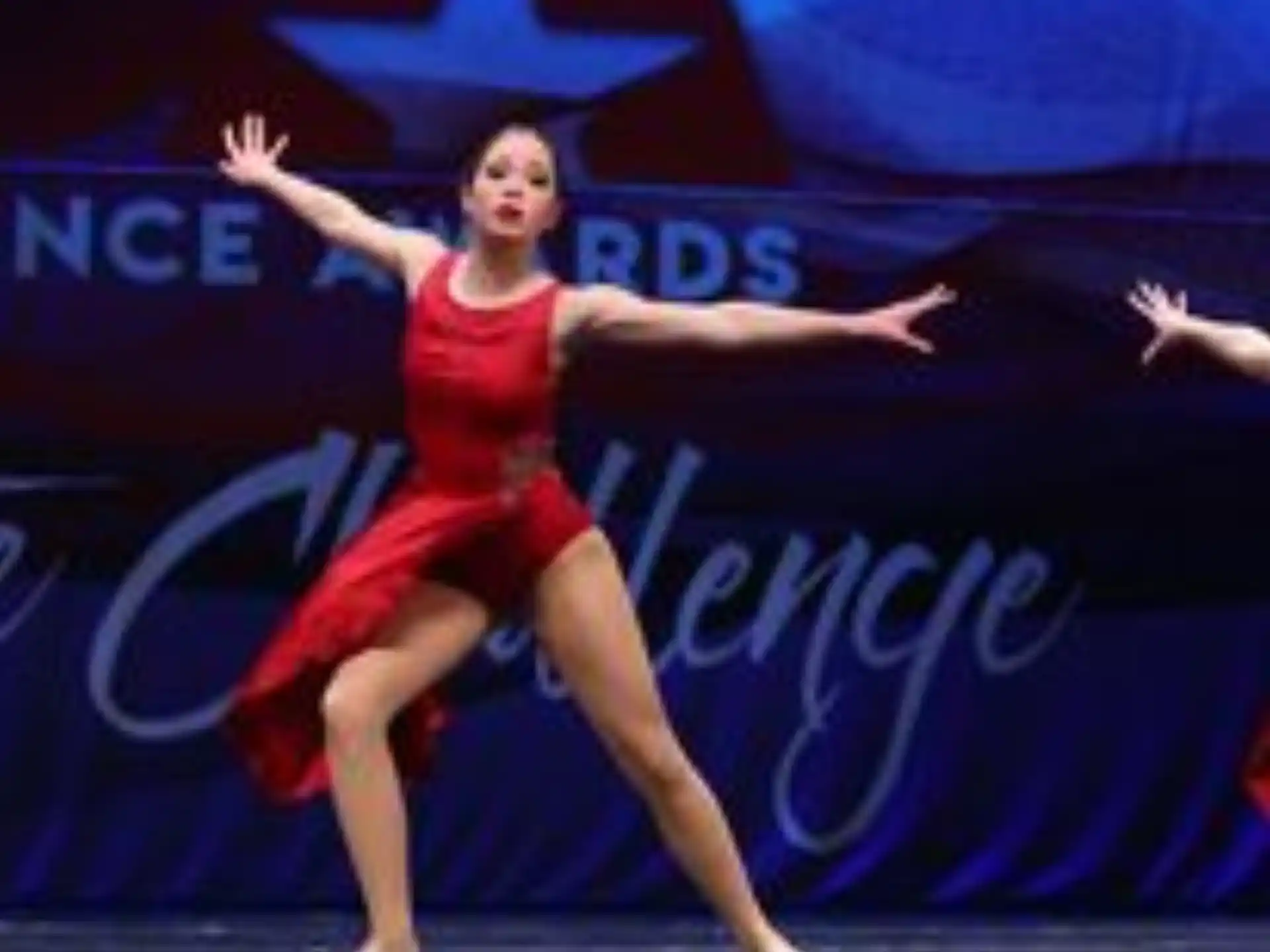 a woman in a red dress dancing on a stage