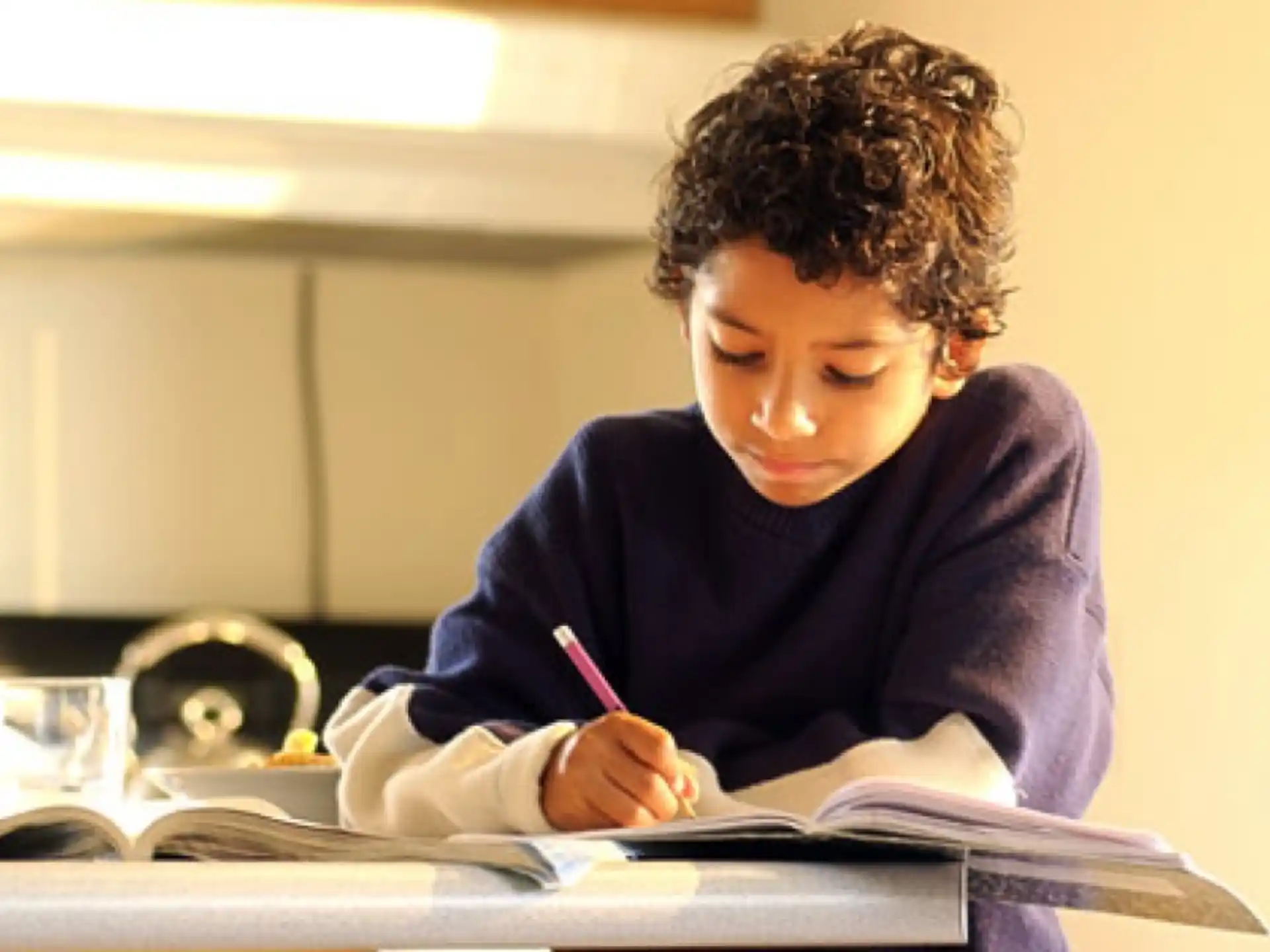 a young girl writing on a book