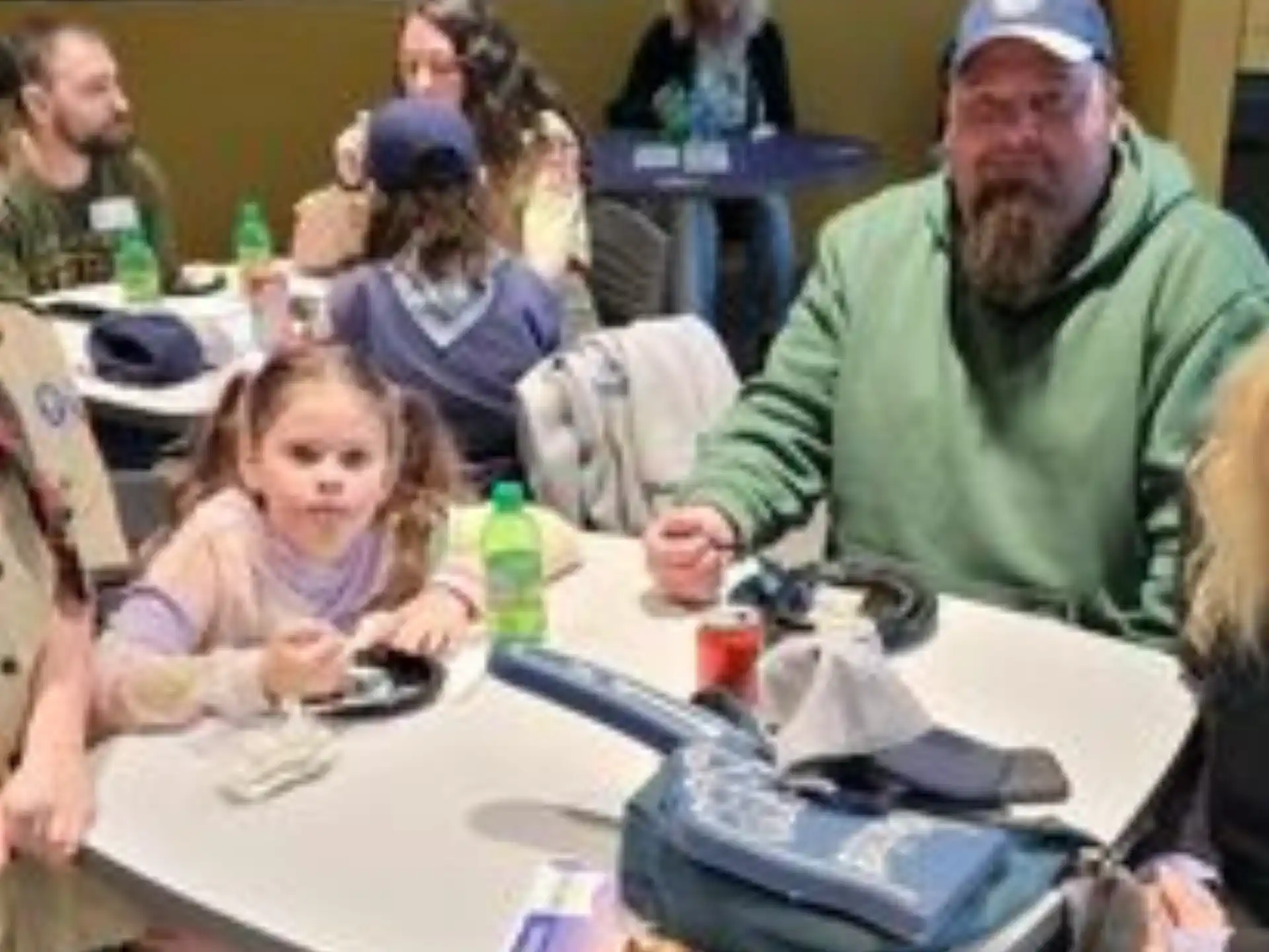 a person sitting at a table with a group of children