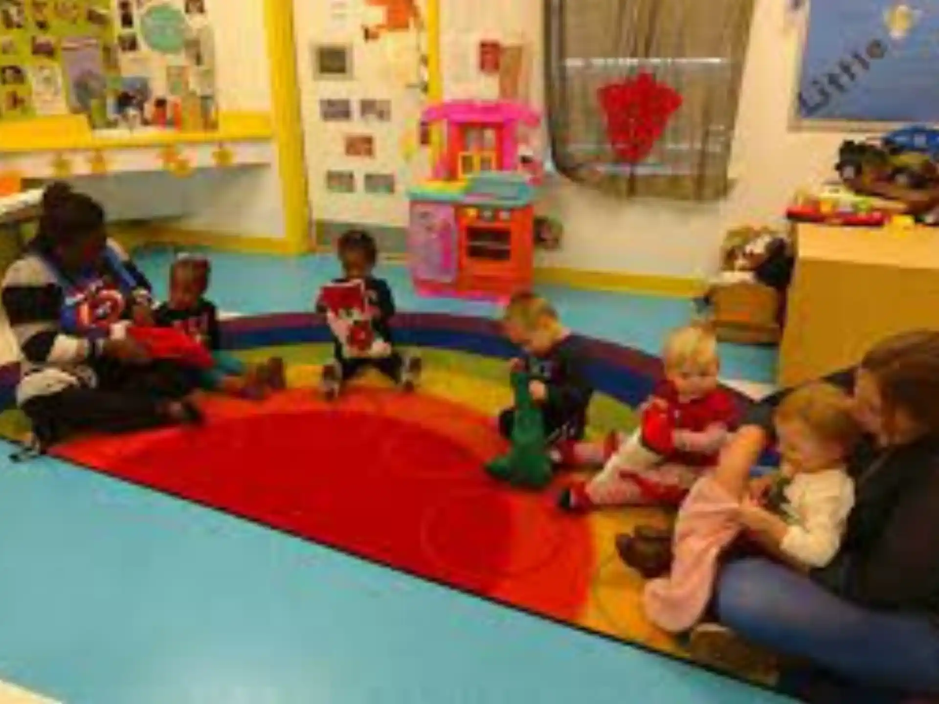 a group of children sitting on the floor in a classroom