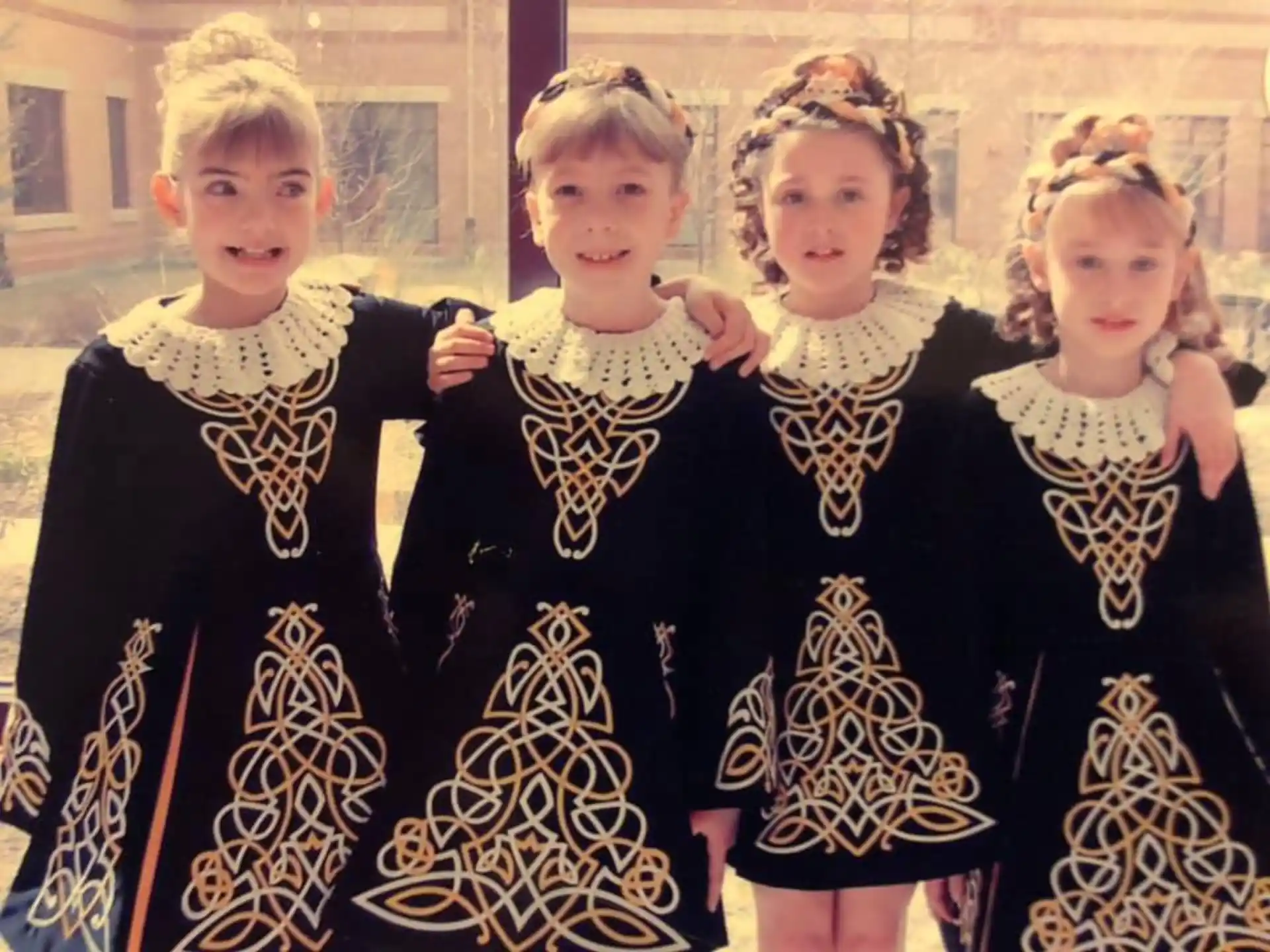 a group of children in black and white dresses